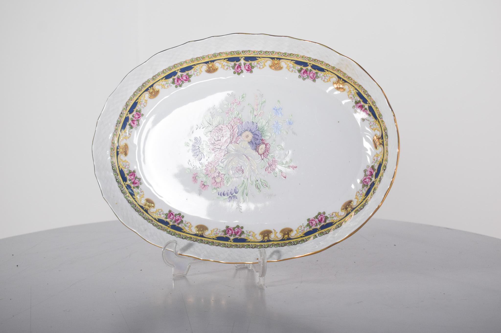 Plat de service ovale en porcelaine de Limoges. L'une des plus prestigieuses manufactures françaises de porcelaine, reconnue pour sa qualité et sa beauté. Le plateau présente un délicat fond blanc, orné d'une riche décoration florale au centre,