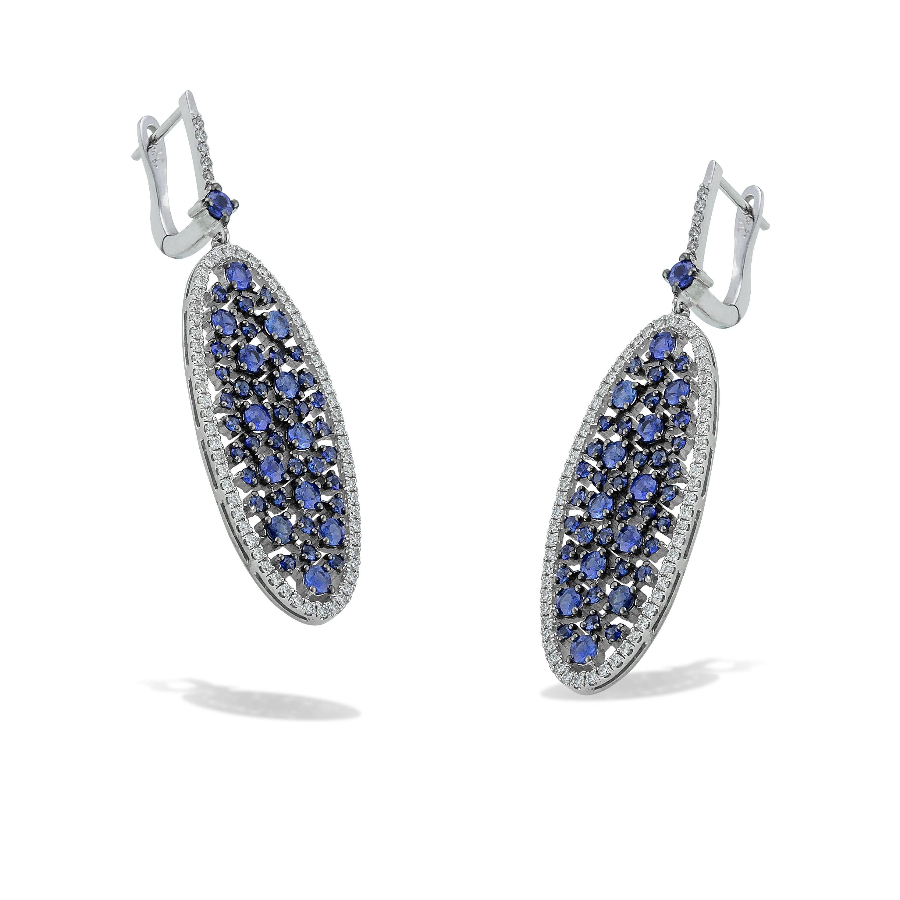 Oval long dangle earrings with round Blue Sapphires and pave white brilliant cut diamonds handcrafted in 18Kt white gold. This breathtaking piar of earrings speaks volumes as it glimmers with natural brilliance. The Blue Sapphires captures the power