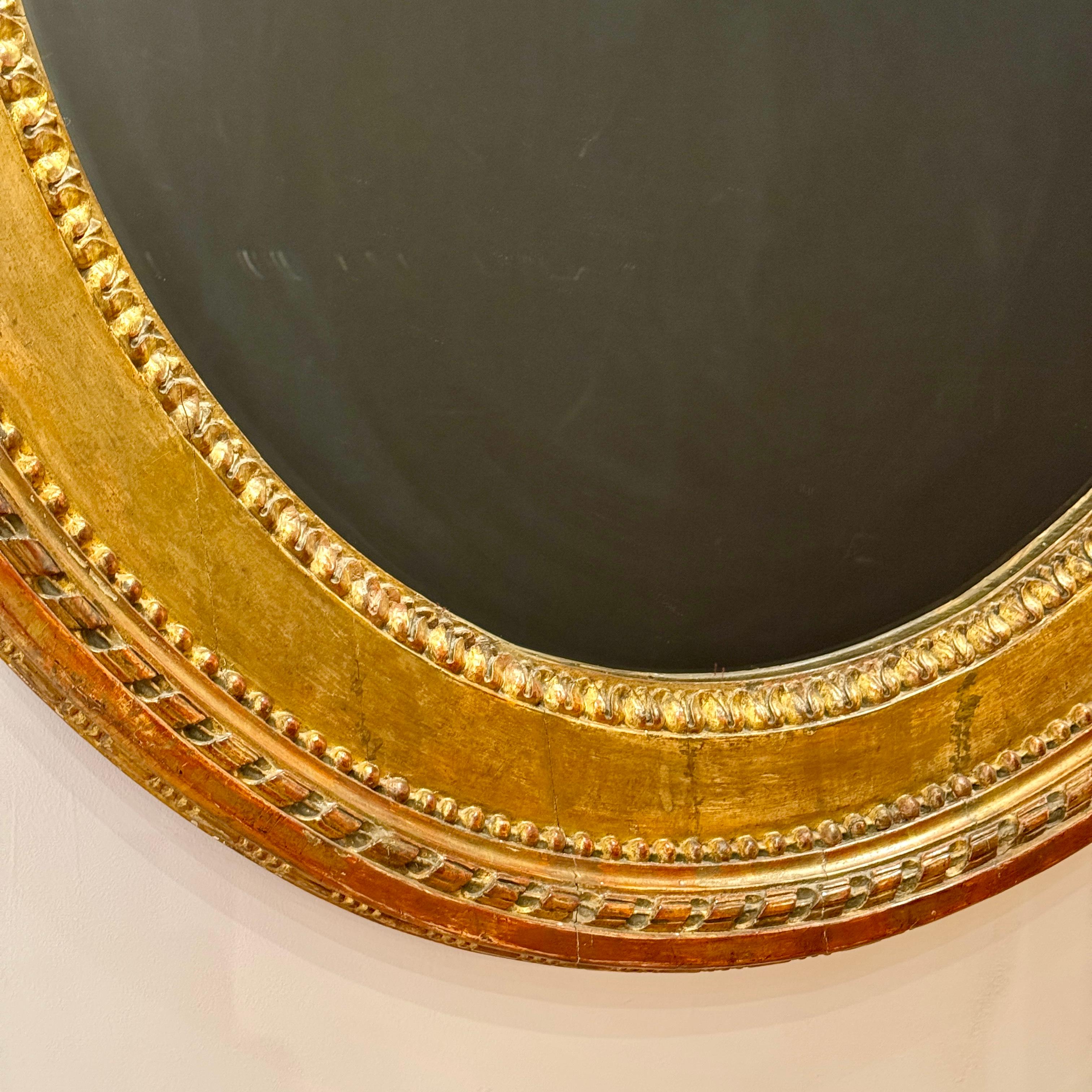 XVIIIe siècle Miroir ovale Louis XVI en bois doré en vente