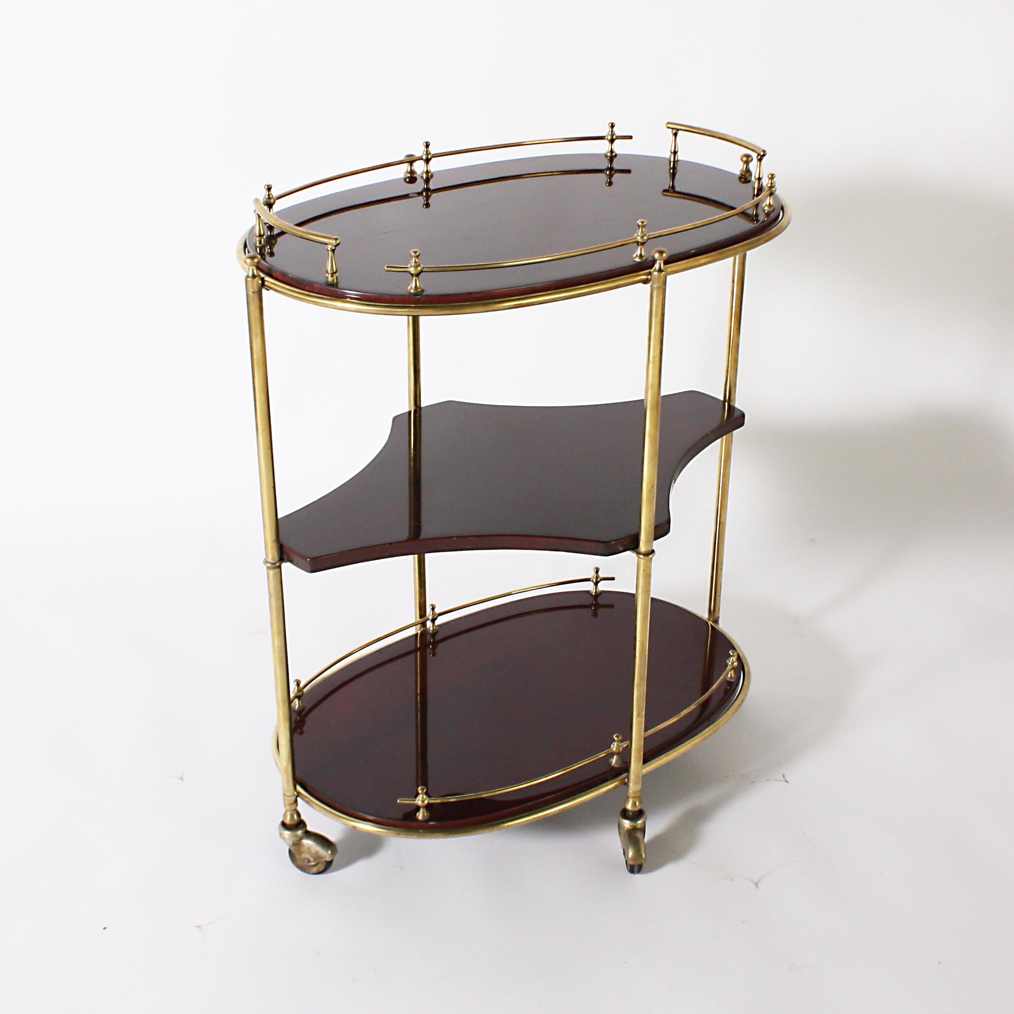 Oval mahogany drinks cart with brass details, circa 1950.
    