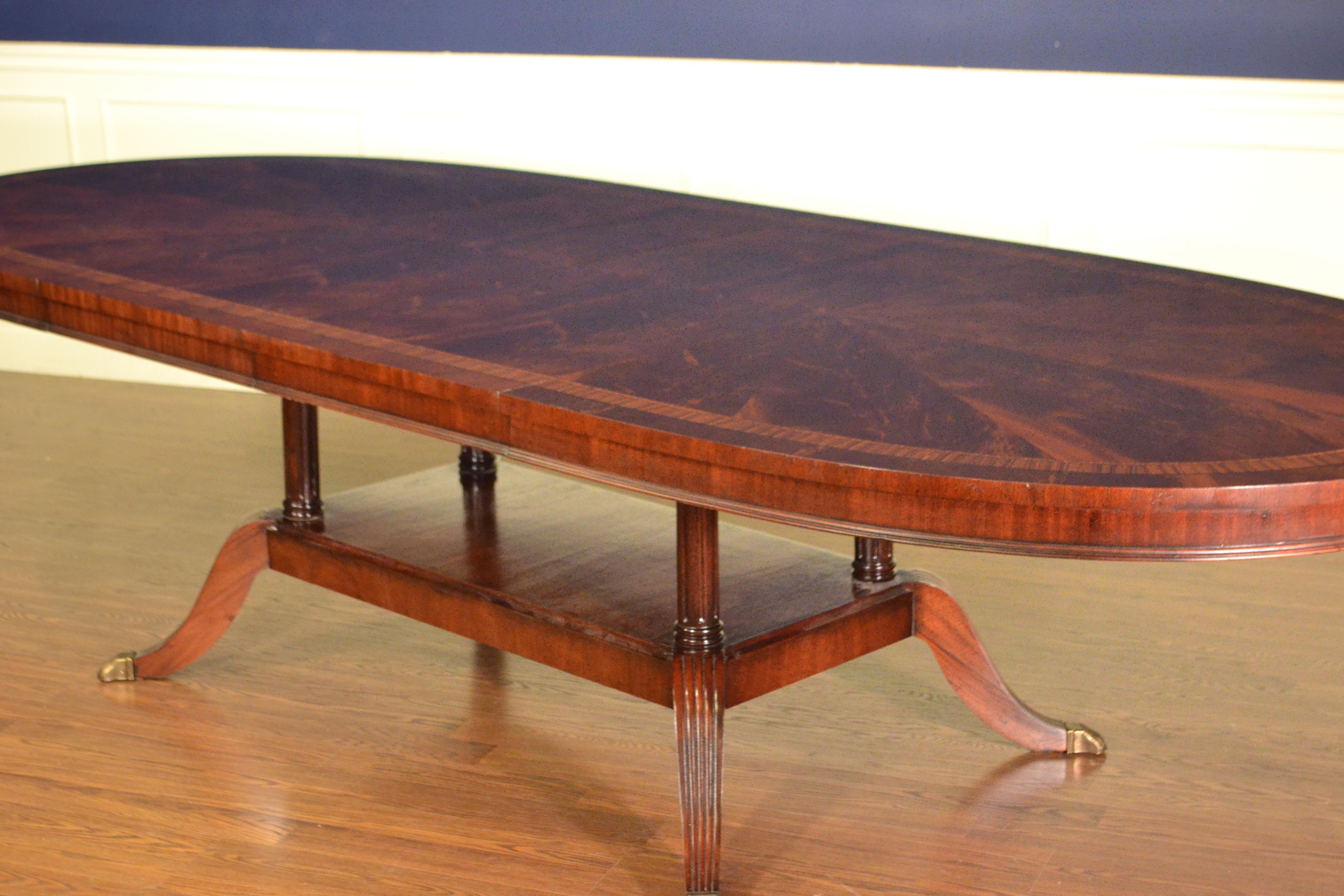 This is made-to-order oval traditional mahogany dining table made in the Leighton Hall shop. It features a radial cut field of west African swirly crotch mahogany and two borders of santos rosewood and crotch mahogany. The top has a hand rubbed and