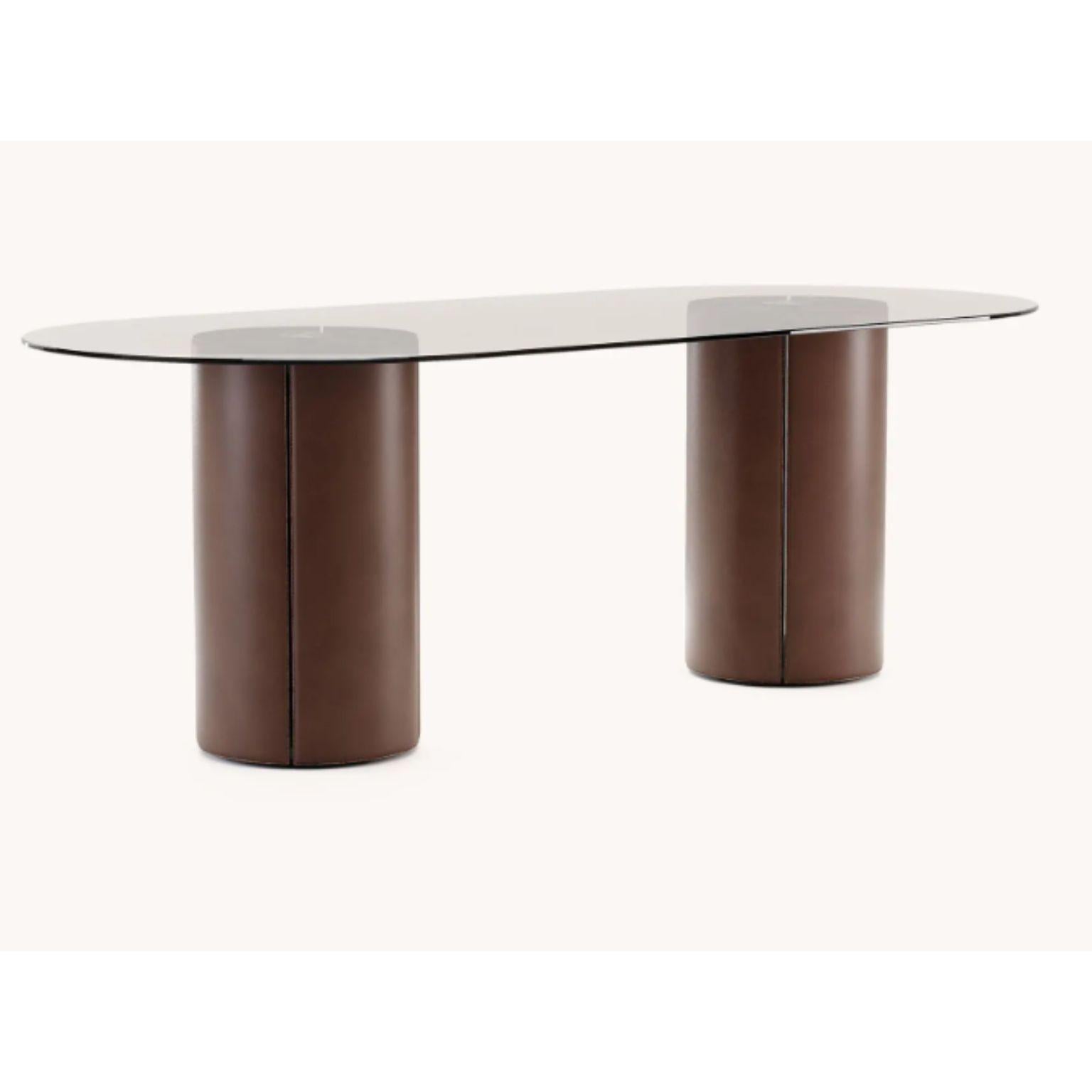 Oval Mano dining table by Domkapa
Dimensions: W 220 x D 100 x H 75 cm.
Materials: Black lacquered matte, natural leather (Albany Terra), bronze mirror.
Also available in different materials.

With classic materials and an outstanding shape,