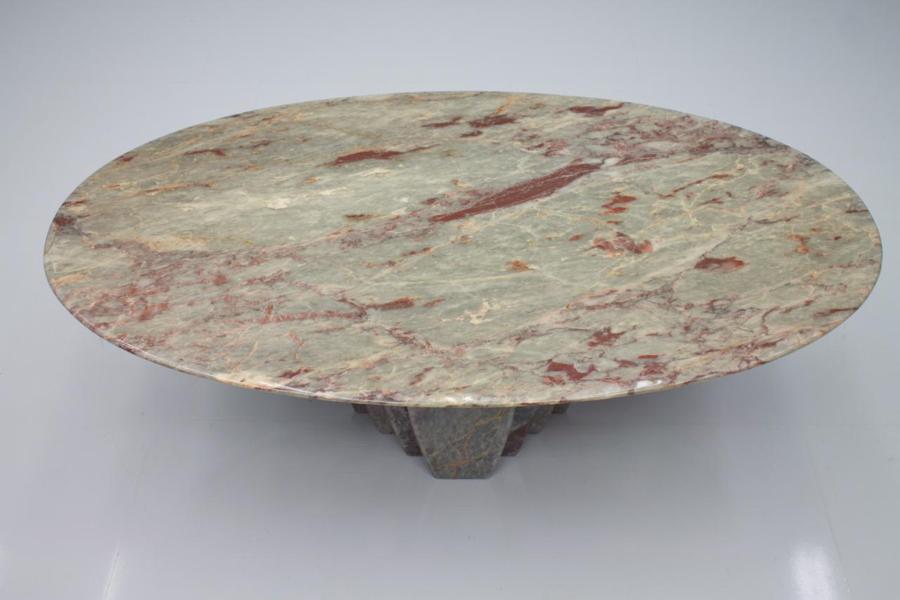 Beautiful marble sofa table in oval shape in grey. white, and red grain. The foot is fan-shaped. 
Measures: W 134 cm, D 78.5 cm, H 46.5 cm. 

Very good condition.