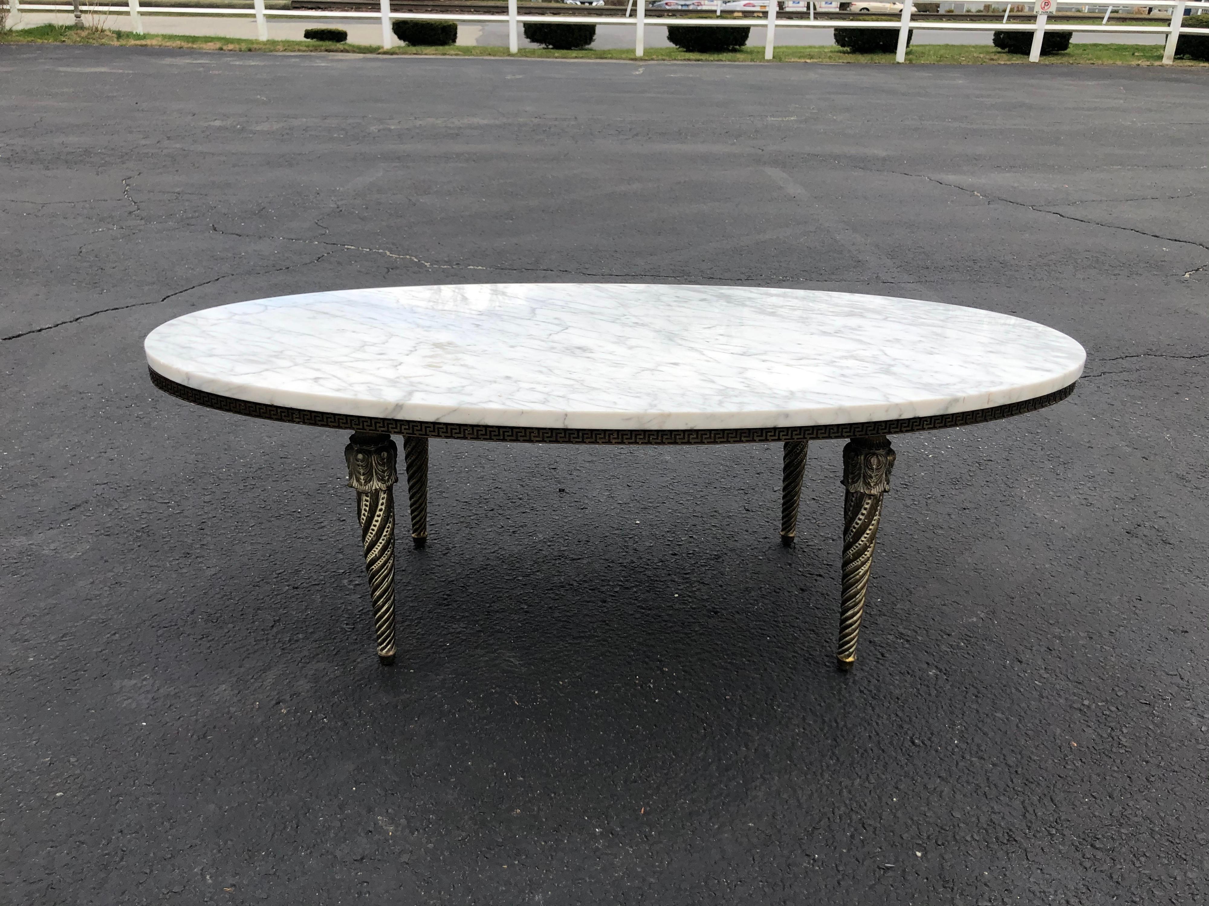 Oval marble-top and brass coffee table. Stunning midcentury gem. With its turned bras legs and brass gallery. Great with any Hollywood Regency style decor.