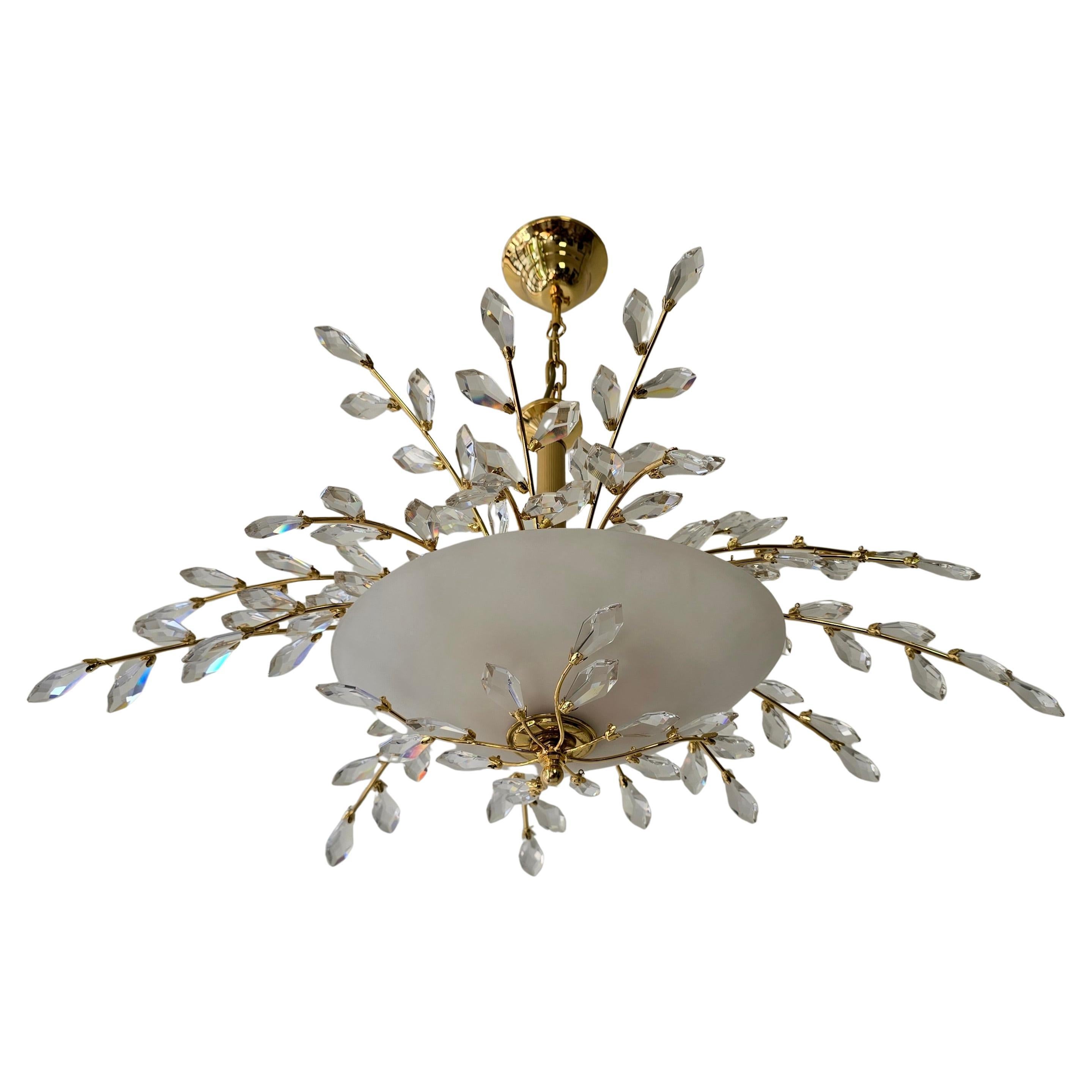 Oval Mid-Century Chandelier in Brass, Crystal and Opaline Glass – 1970s

Elegant oval chandelier from the 1970s, crafted from brass with shimmering crystal accents and a central opaline glass shade. The delicate, branch-like arms adorned with