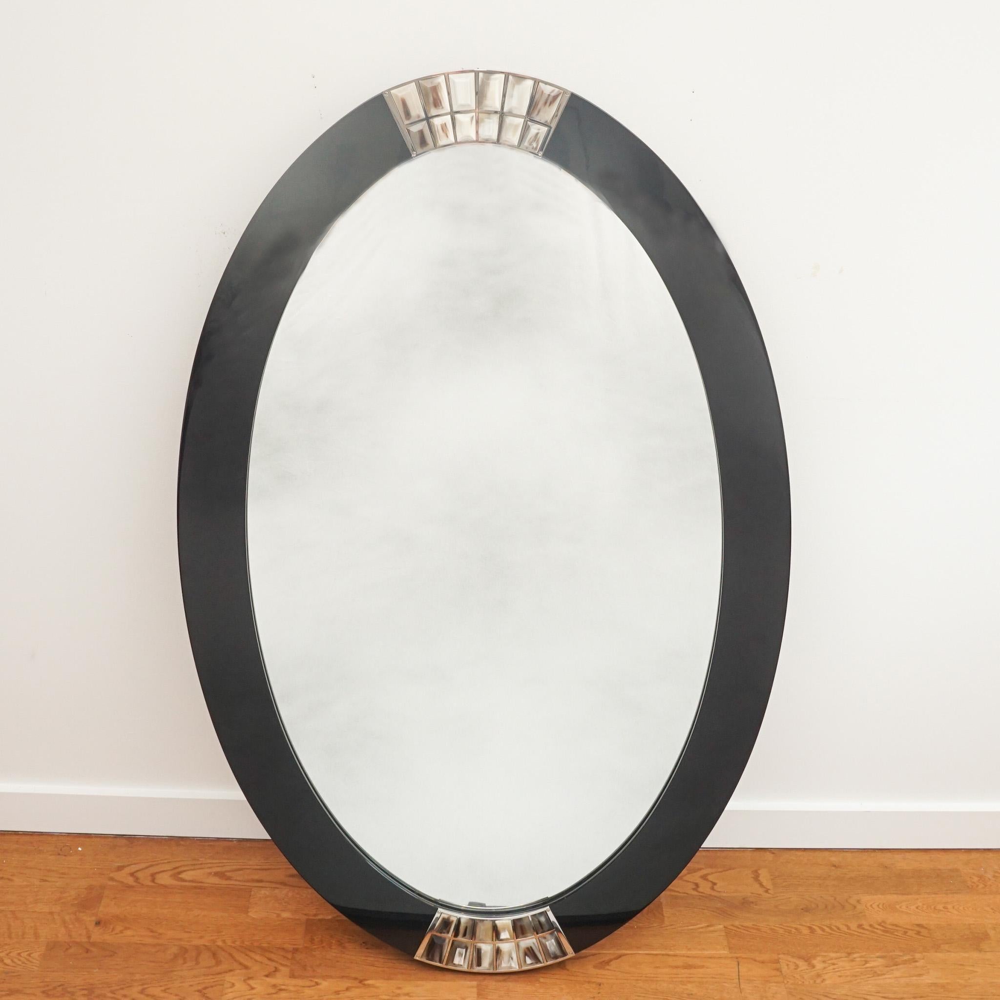 This exquisite Arcahorn oval mirror exemplifies the quality craftsmanship and luxurious finishes for which the company is known.  Featuring a black lacquer frame detailed top and bottom with natural horn, it is certain to make a statement wherever