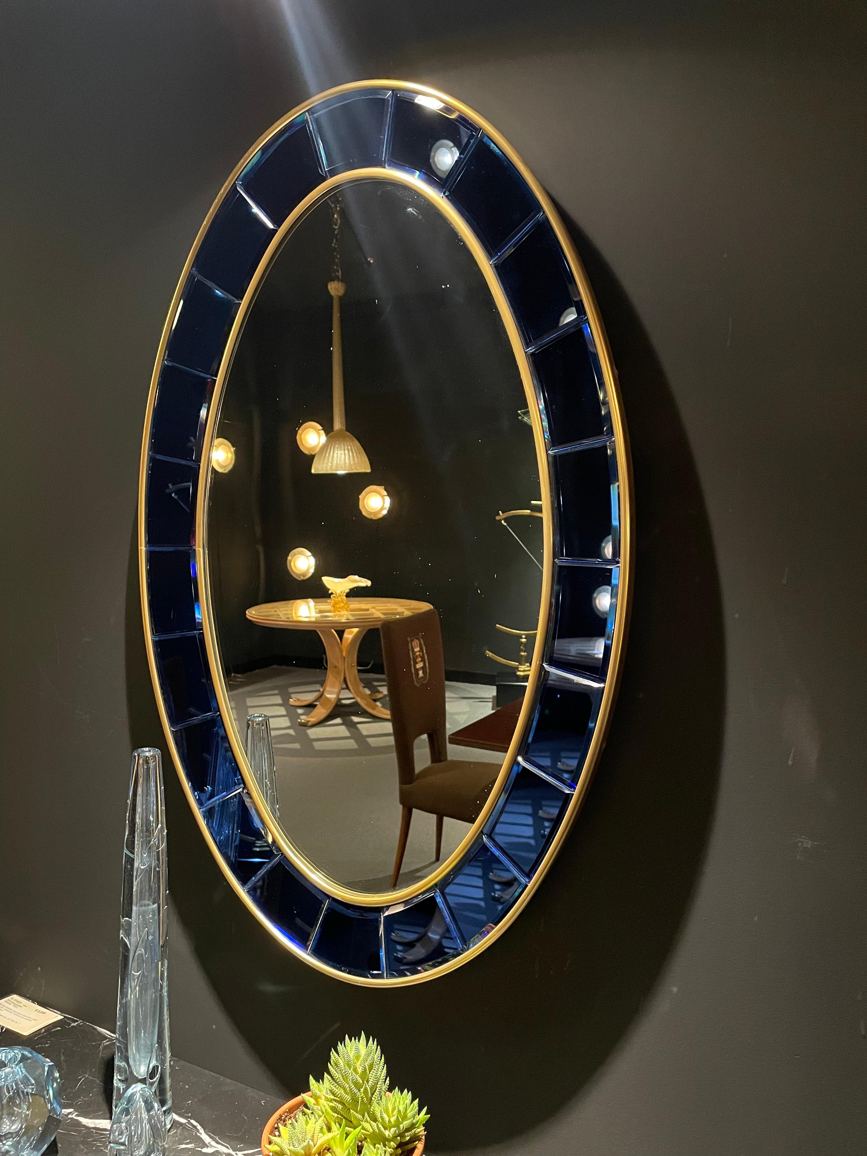 
Mirrored clear glass encompassed by a gallery of bright blue, beveled, and mirrored glass with gilded bronze trim.