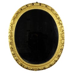 Antique Oval Mirror in a Carved and Gilded Wood Frame from the 18th Century