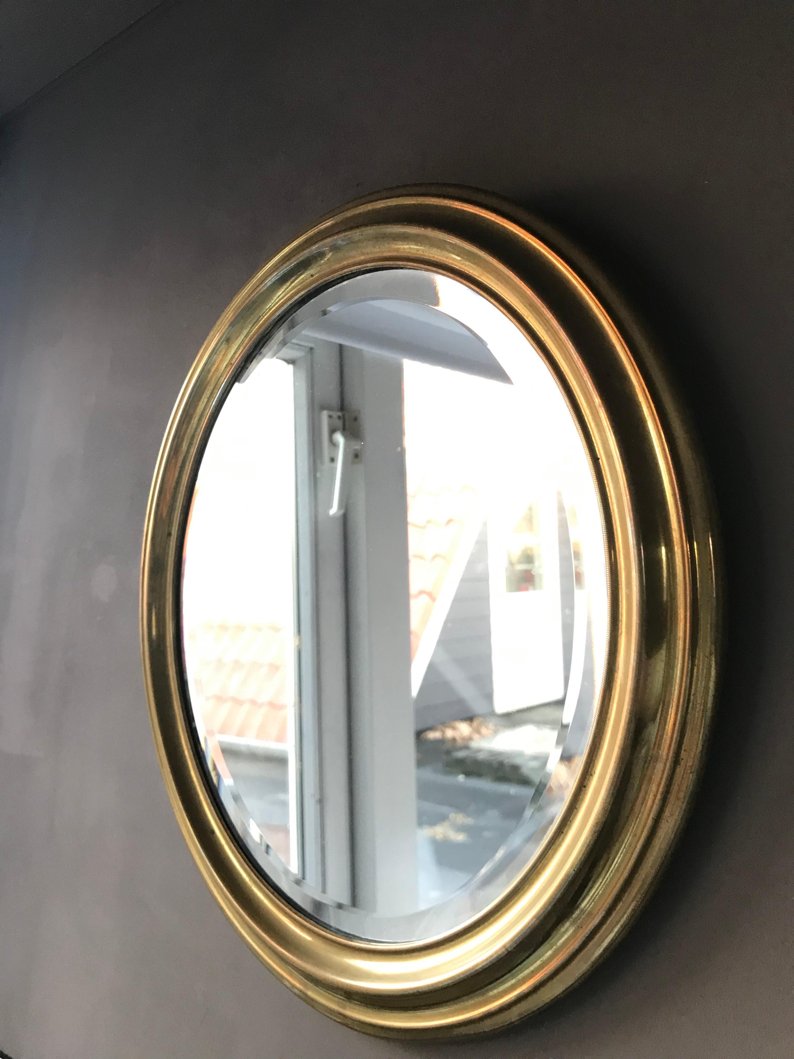 Oval mirror in brass, mirror glass with cut edge.