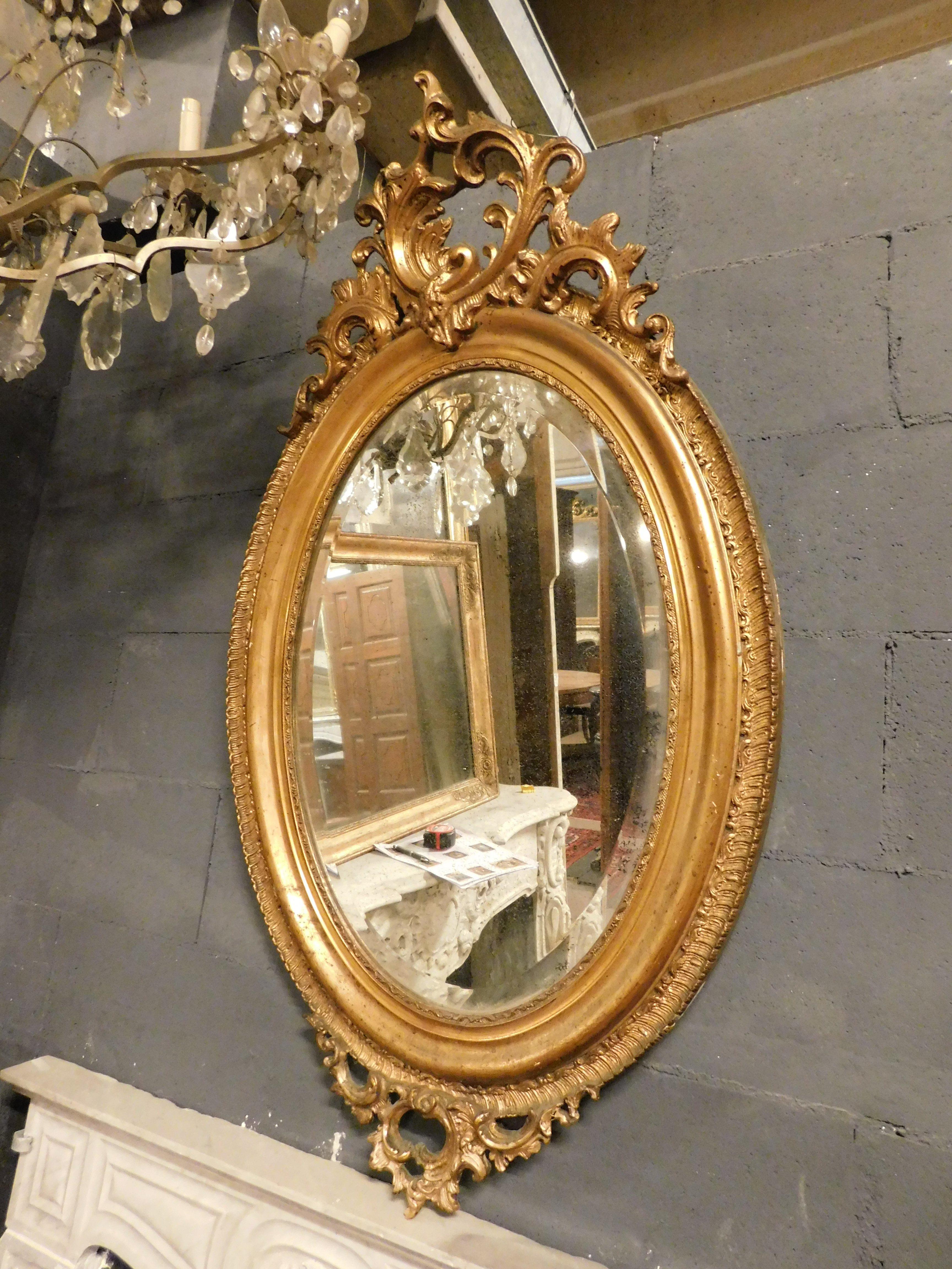 French Oval mirror in gilded wood with carved cymatium, France