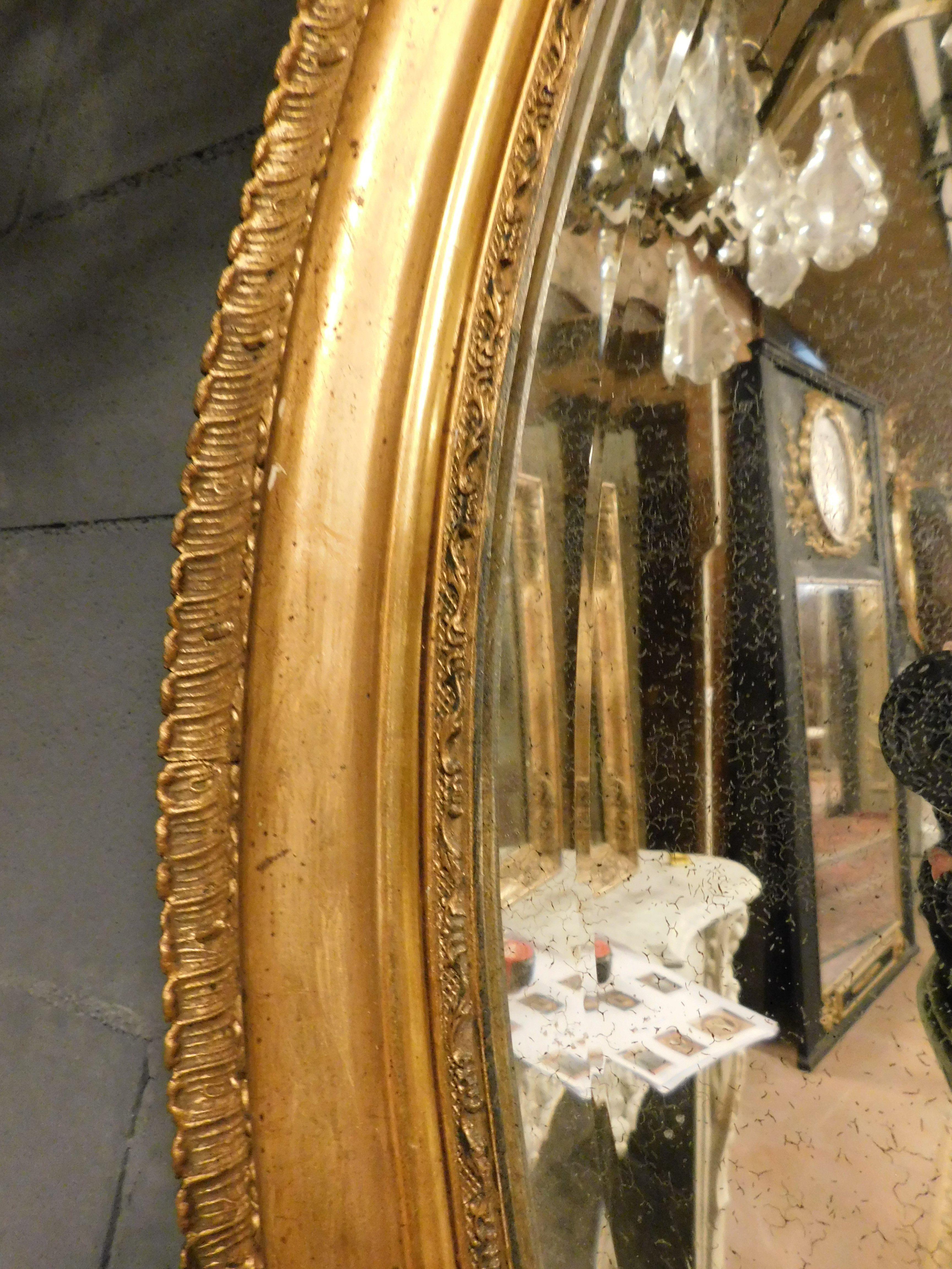 Poplar Oval mirror in gilded wood with carved cymatium, France