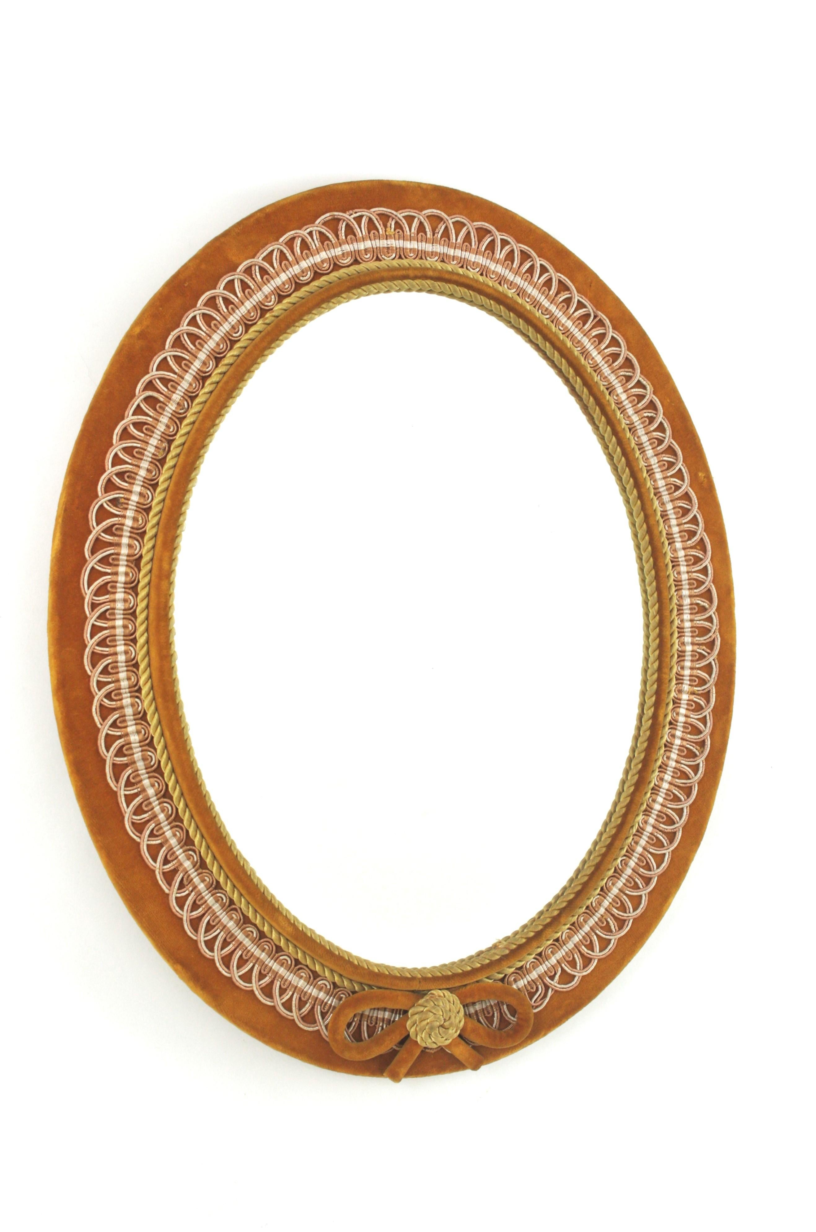 Amber / Ochre Yellow Velvet Oval Mirror, Spain, 1950s-1960s
Kitsch style mirror with yellow-ocher velvet upholstered frame with twisted silk cord and trimming details surrounding the glass and a highly decorative bow ribbon at the bottom