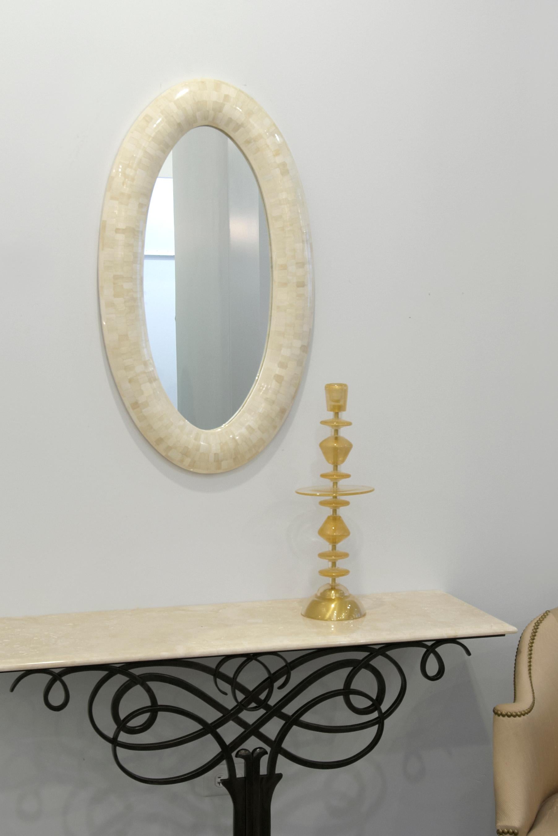 Made of solid wood and topped with camel bone chips, this mirror frame adds a calming magnificence to any space. Each chip is hand carved in small hexagons to align with the convex wood frame. It includes a high shine mirror.
Also available in horn