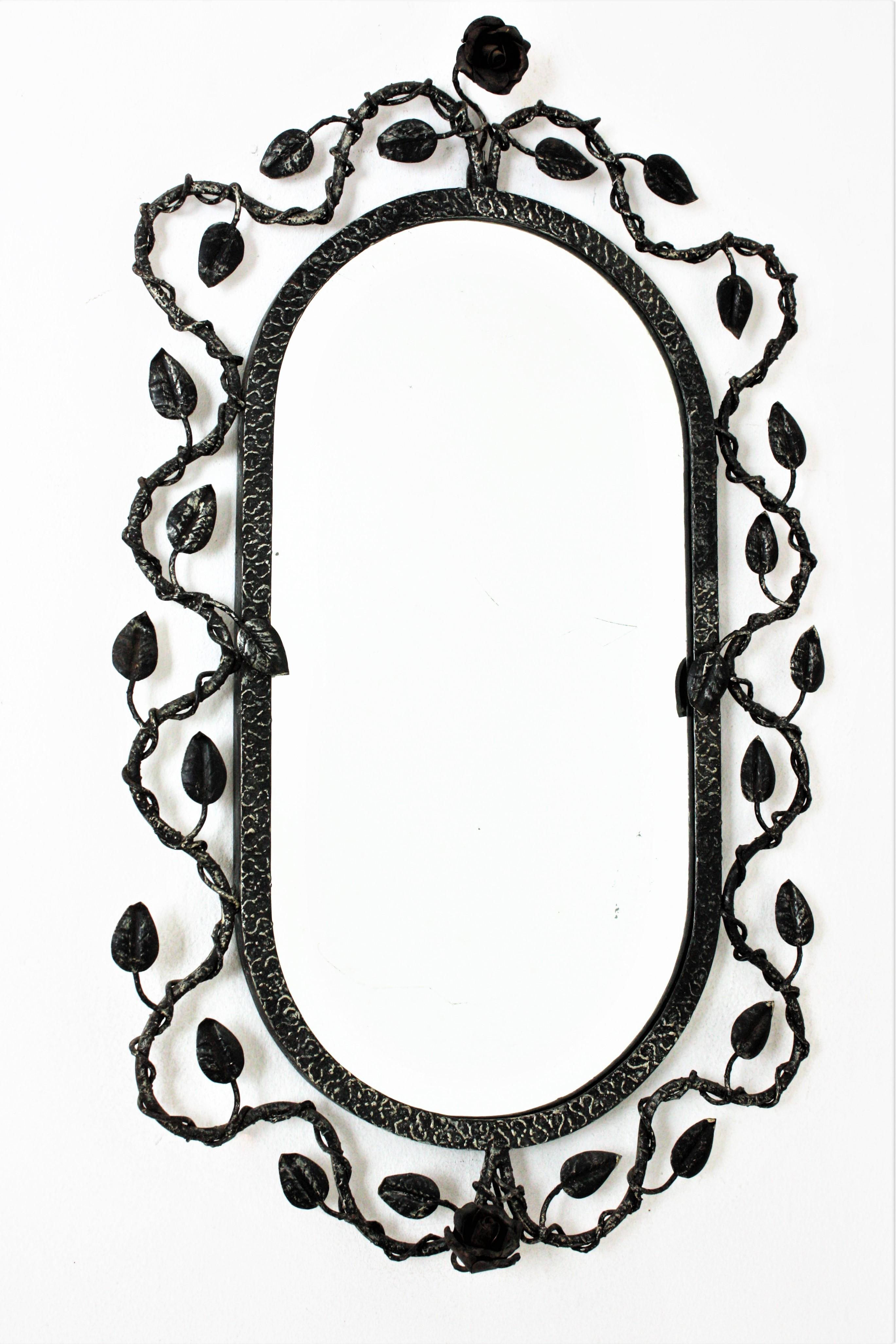 Foliage Floral Oval Mirror in Silver Silver Patinated Hand Forged Iron, Spain, 1950s.
Hand wrought iron oval sunburst wall mirror with foliage frame , patinated finish and floral accents.
The frame features and intrincate of branches and leaves with