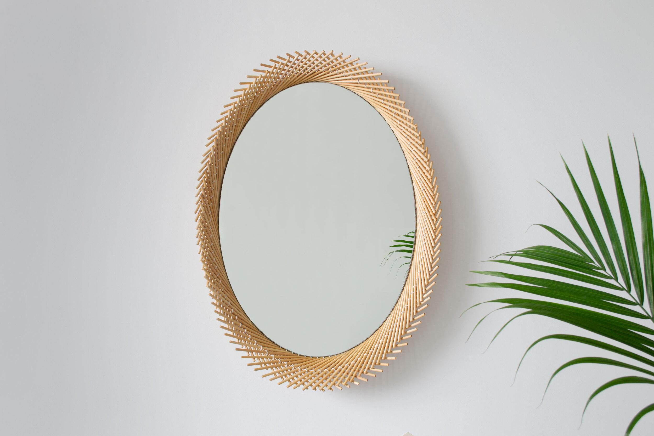 The Oval Mirror pushes the strict geometry that occurs as a result of stitching the dowels together to create a dynamic edge. Each layer of the Mooda rises and falls inversely to the other as they travel along the circumference of the mirror, giving