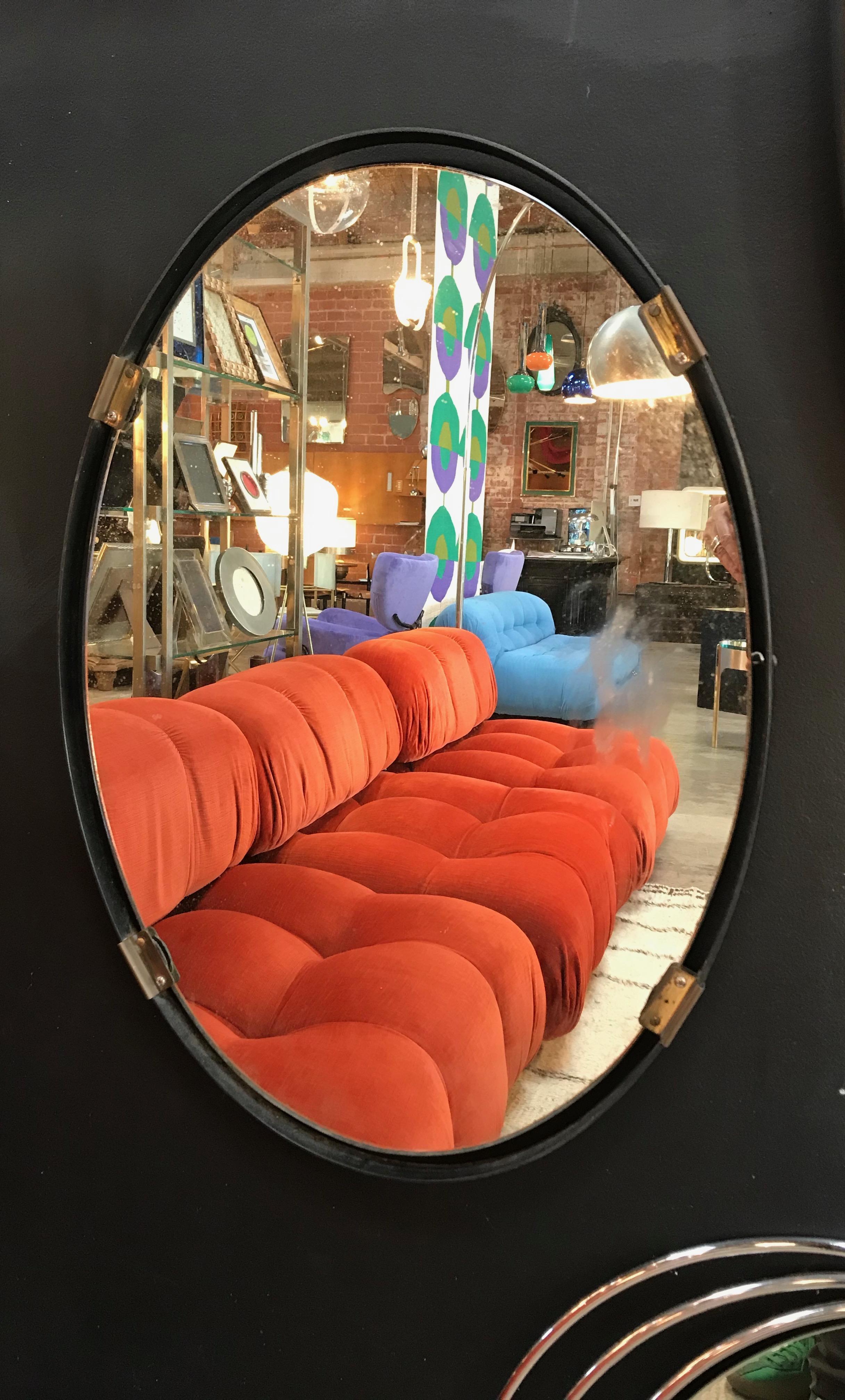 Oval mirror found in Italy features an dark iron, floating-style frame that accentuates the shape and height of this mirror, circa 1970s. Unknown maker.