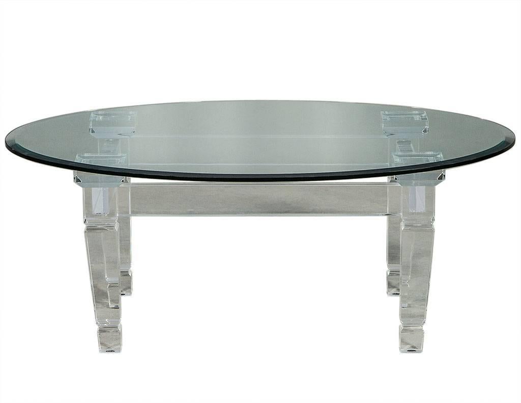 This modern cocktail table is composed of an acrylic base and tapered square legs.  Topped by a large, oval beveled glass top – perfect in an avantgarde home!