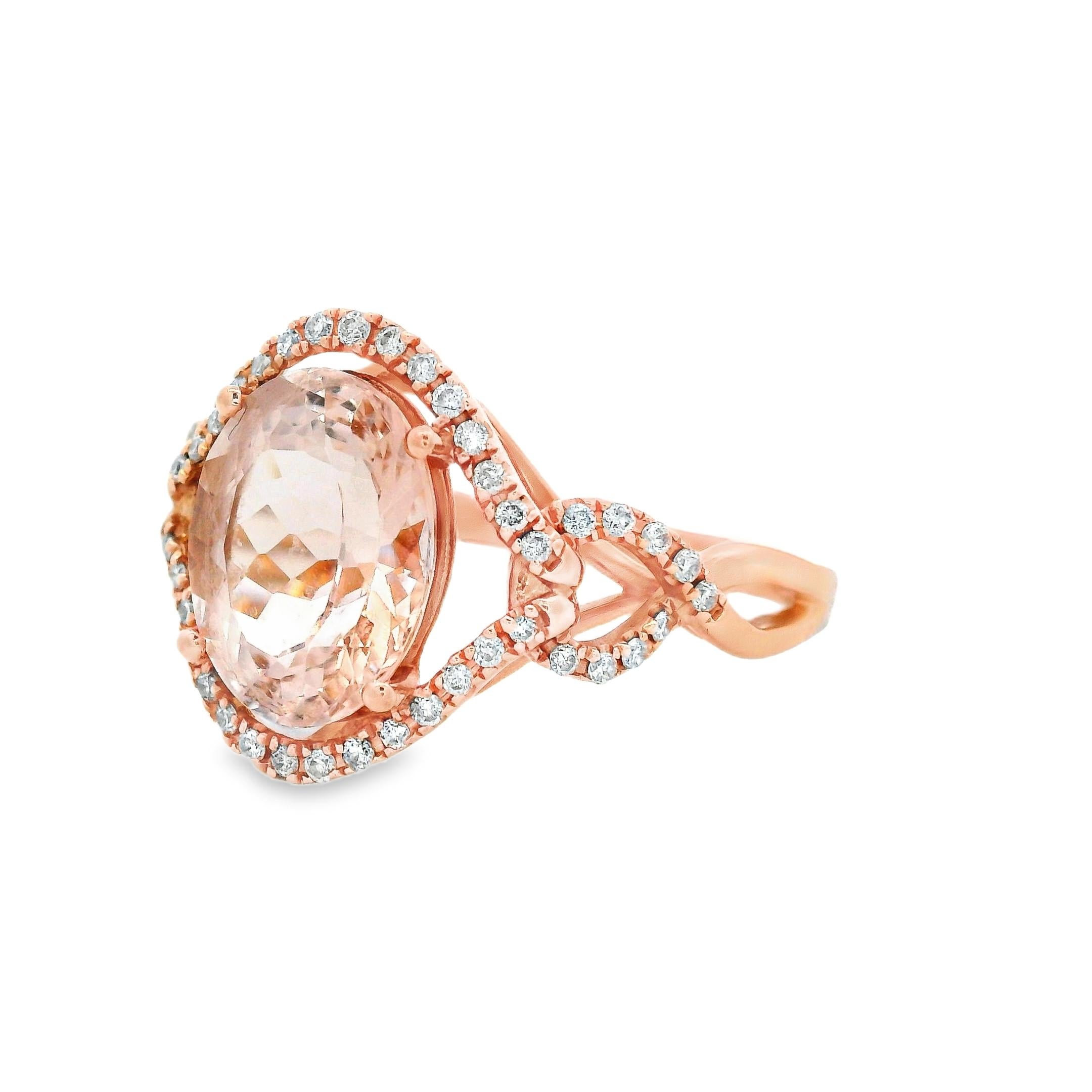 Este femenino anillo de cóctel presenta una morganita ovalada de 2,30 quilates y 10 x 8 mm, asegurada en oro rosa de 14 quilates. El suave tono rosa rubor de la morganita se ve acentuado por un halo de cuarenta y ocho diamantes brillantes redondos,