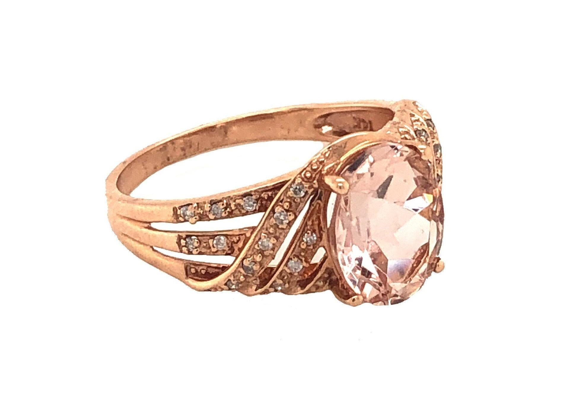 This is a marvelous natural morganite and diamond ring set in solid 14K rose gold. The natural Oval 2.24 CT Morganite (10x8MM) has an excellent peachy pink color ring set on top of a gorgeous diamond encrusted shank. The ring is stamped 14K and is a