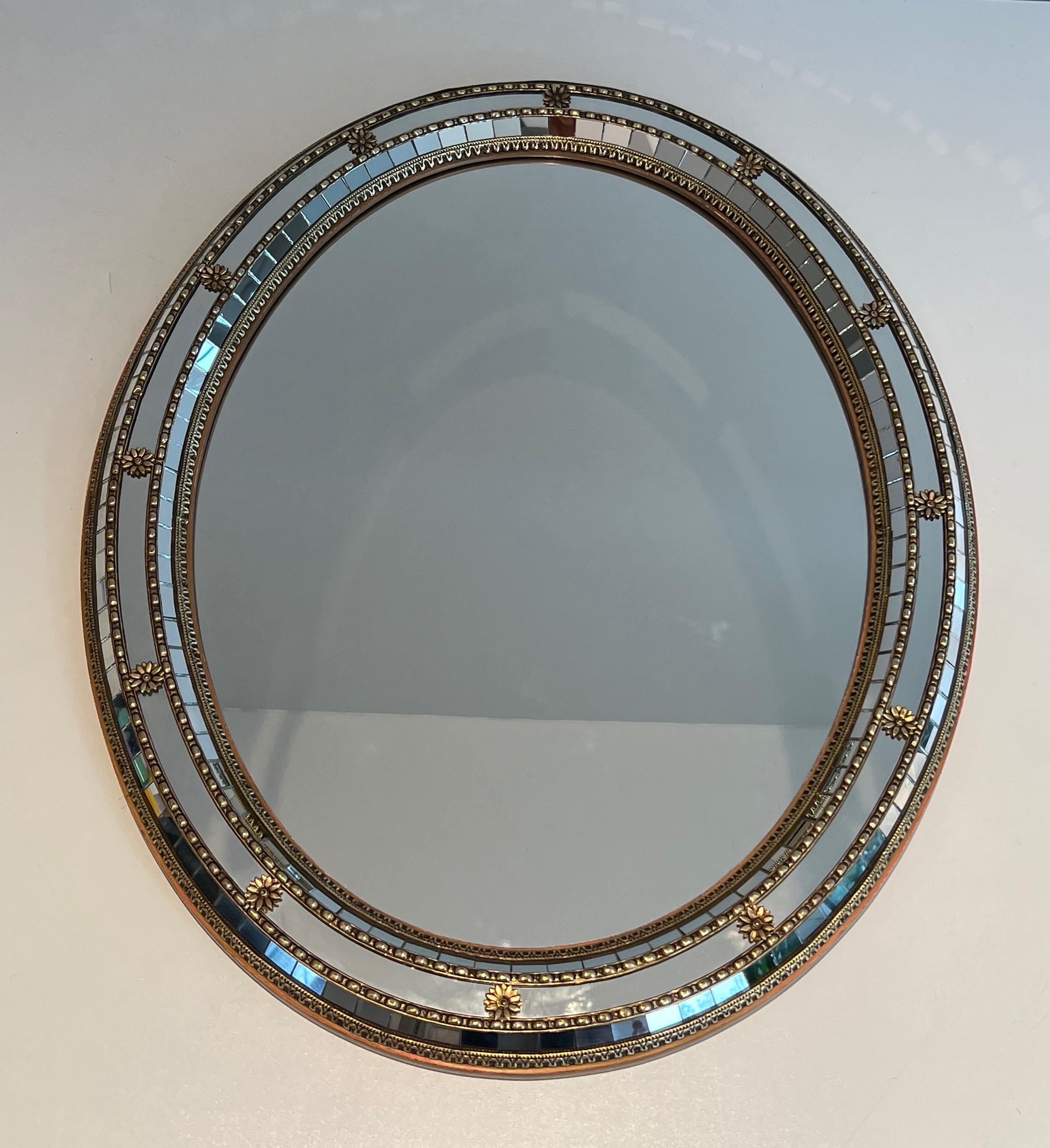 Ce très beau miroir ovale est fabriqué en  multi-facettes avec des guirlandes en laiton. Il s'agit d'un ouvrage français. Circa 1970