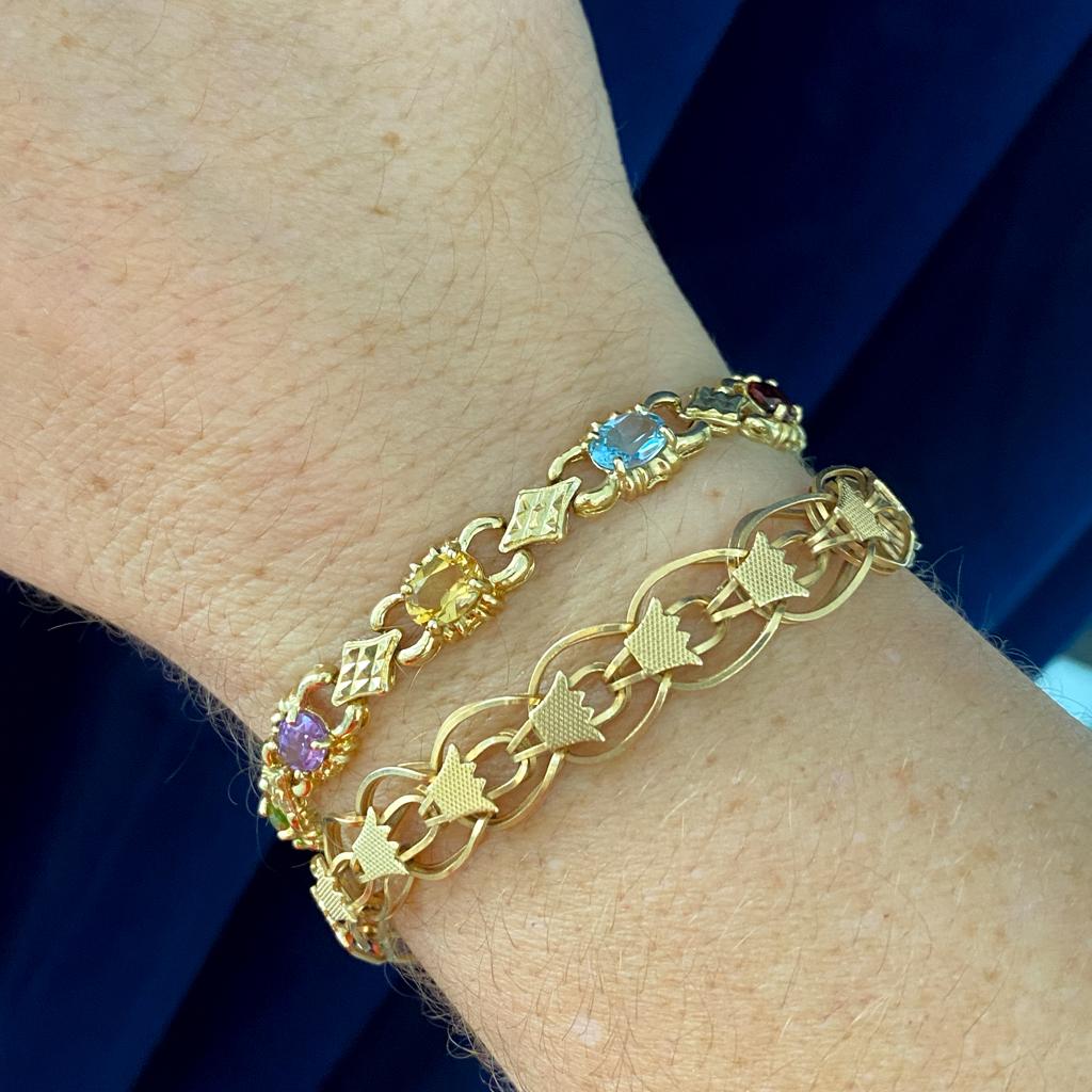 Ce bracelet coloré présente un beau mélange de couleurs de pierres de naissance en or jaune 14 carats robuste. Les pierres précieuses ovales sont la topaze bleue, le grenat, le péridot, l'améthyste et la citrine. Ces pierres peuvent représenter