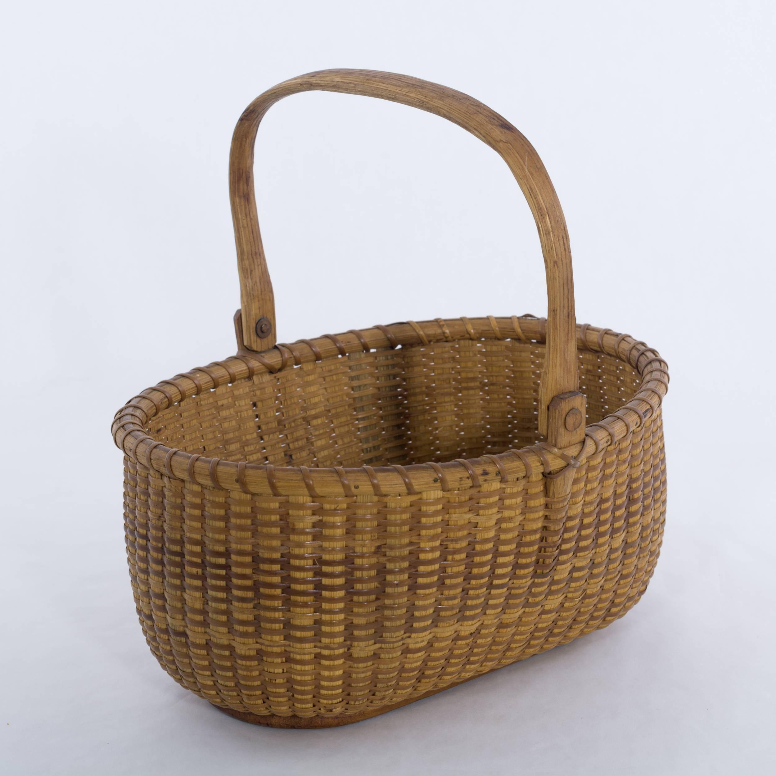 Open oval Nantucket Lightship Basket woven without a mold. Measure: 9 ½”. Having a oak swing handle, staves and ears and Pine bottom and copper fasteners. Signed on the bottom by Jose Reyes with map of Nantucket. Jose Reyes (1902-1980)
circa