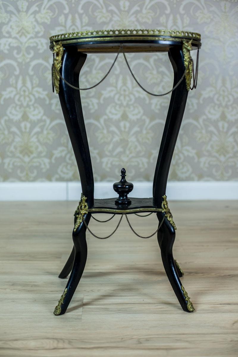 Oval Napoleon III Table, circa 1850

We present you this black small table with an oval top, an openwork gallery made of brass, and an ornament.
The table top is placed on the cabriole legs, which are connected with a stretcher in the shape of a
