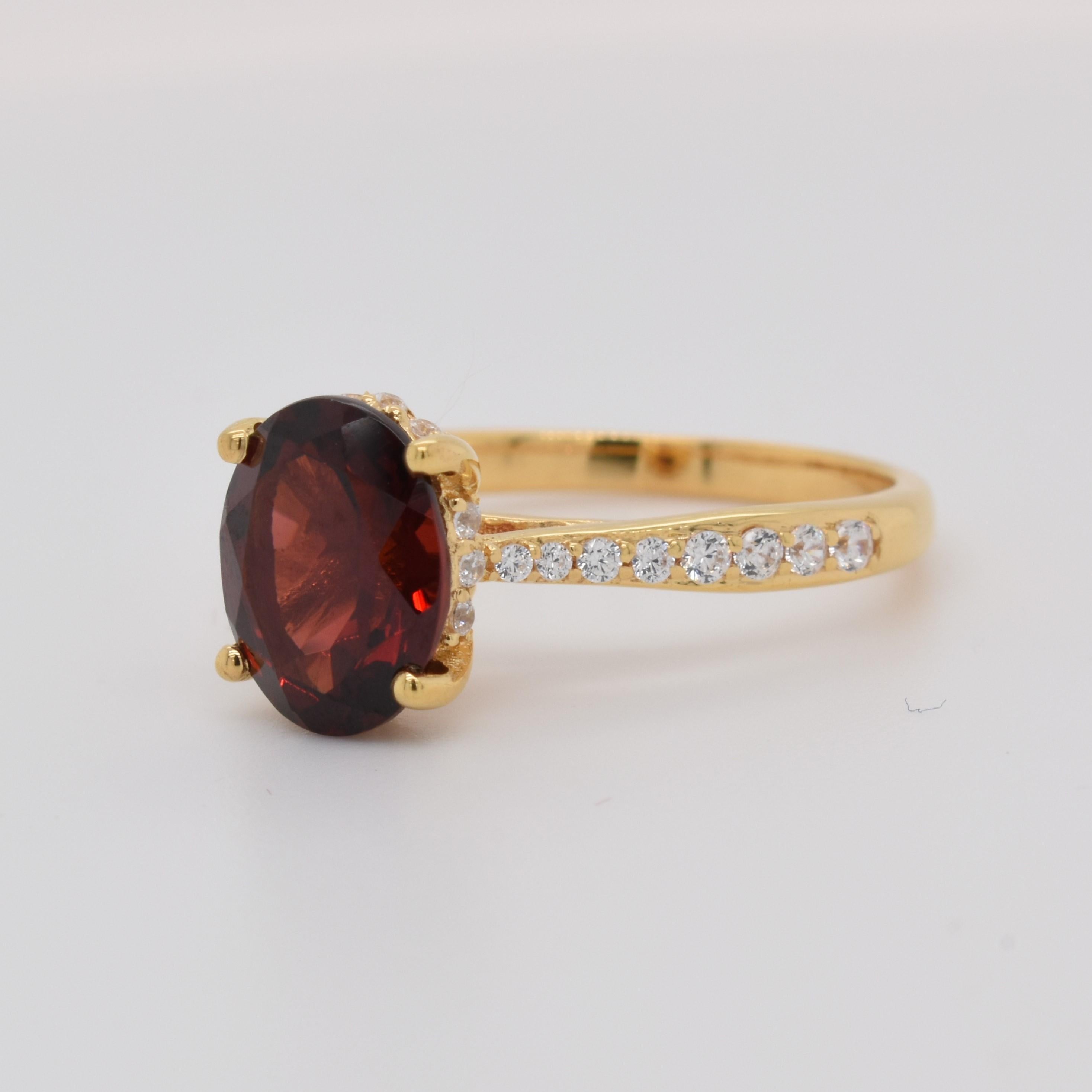 Oval Shape Garnet Gemstone beautifully crafted with CZ in a Ring. A fiery Red Color January Birthstone. For a special occasion like Engagement or Proposal or may be as a gift for a special person.

Primary Stone Size - 9x7mm