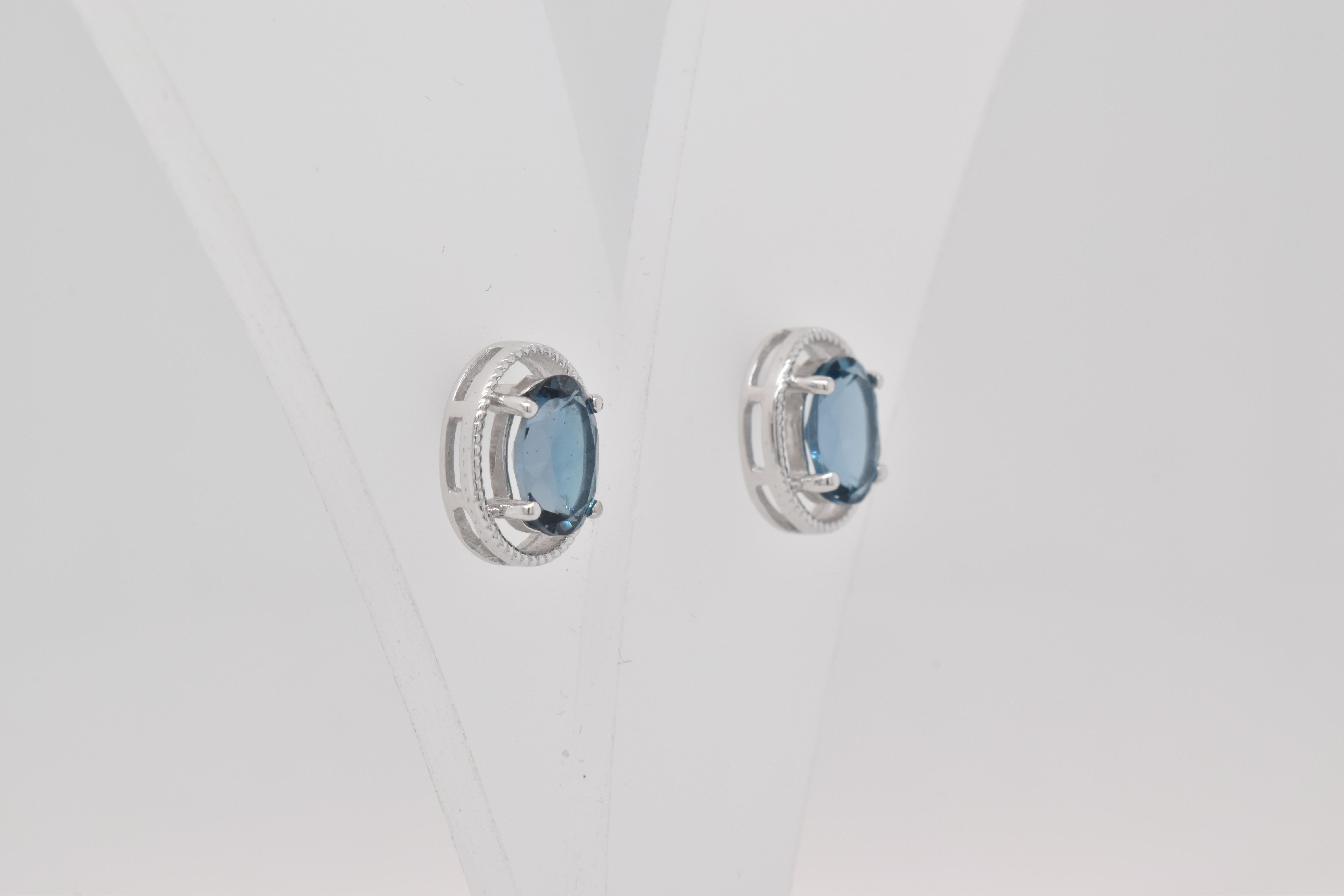 Ovale Form Londoner Blautopas Edelstein  handwerklich schön gemacht  in einem Ohrring. Ein feurig blauer Dezember-Geburtsstein. Für einen besonderen Anlass wie Verlobung oder Heiratsantrag oder als Geschenk für einen besonderen