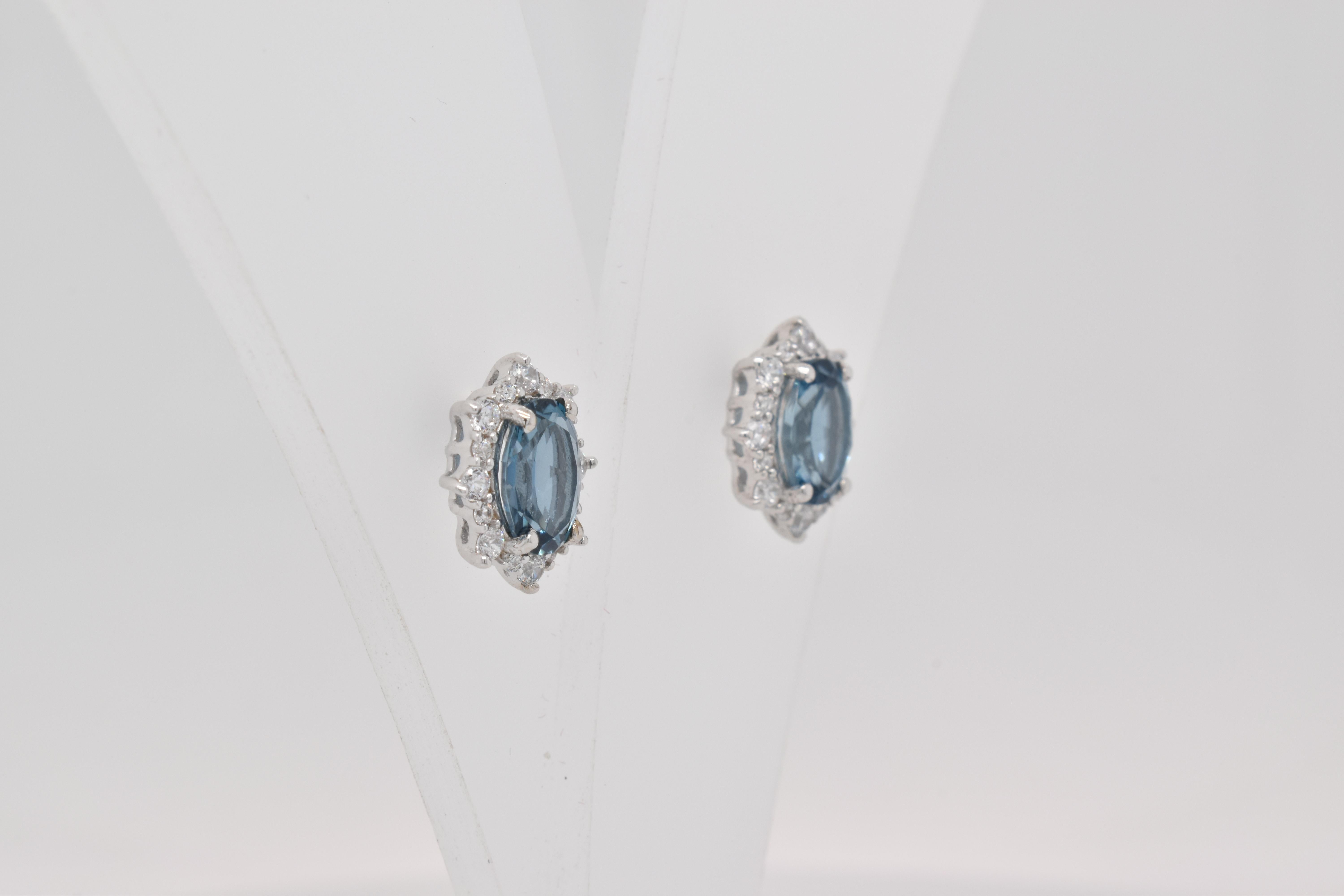 Oval Shape London Blue Topaz beautifully surrounded with CZ crafted in a Earrings. A fiery Blue color December Birthstone. For a special occasion like Engagement or Proposal or may be as a gift for a special person.

Primary Stone Size - 7x5mm
