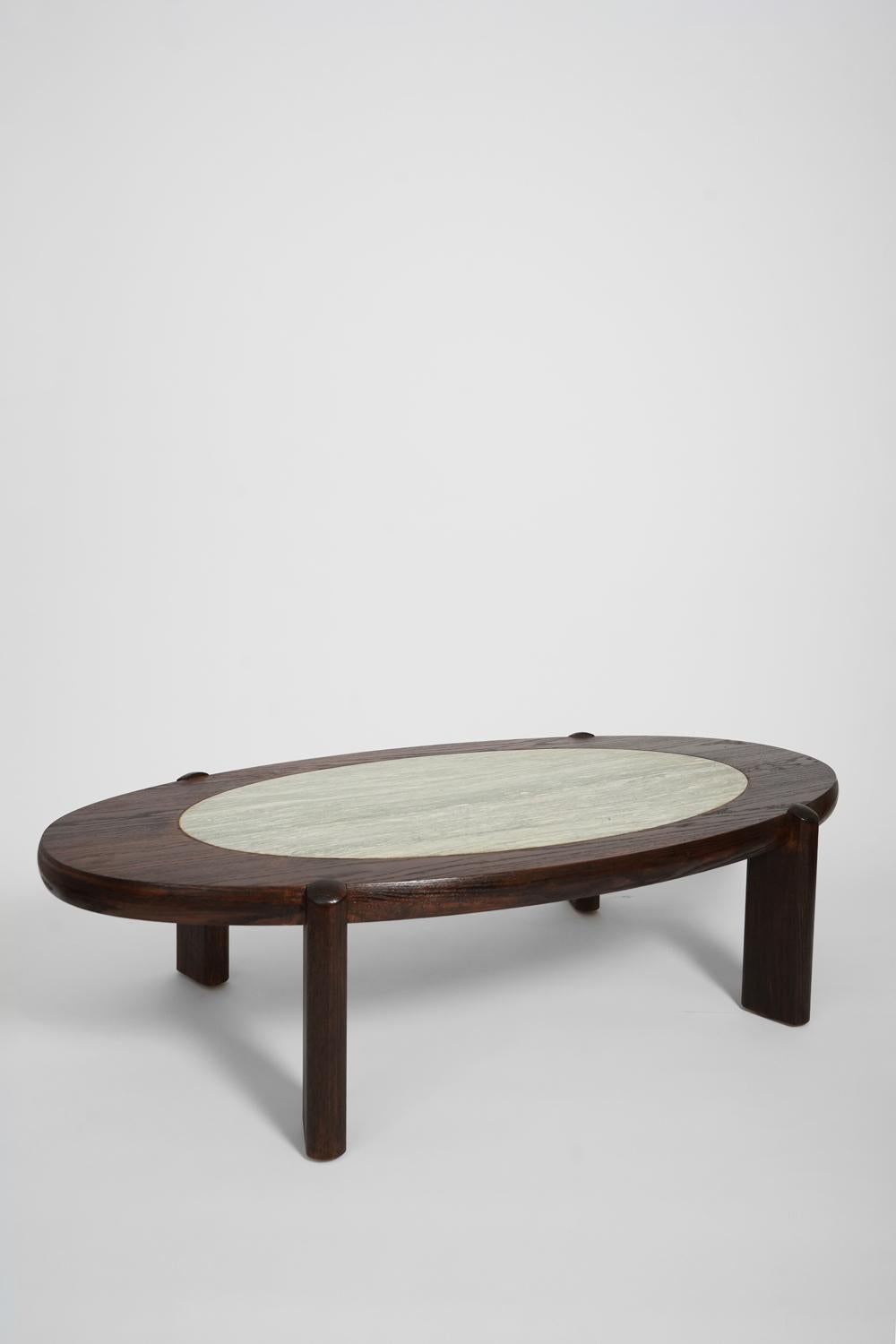 Large oval oak coffee table resting on four legs supporting a blue veined granite slab in the center. France, 1960s.