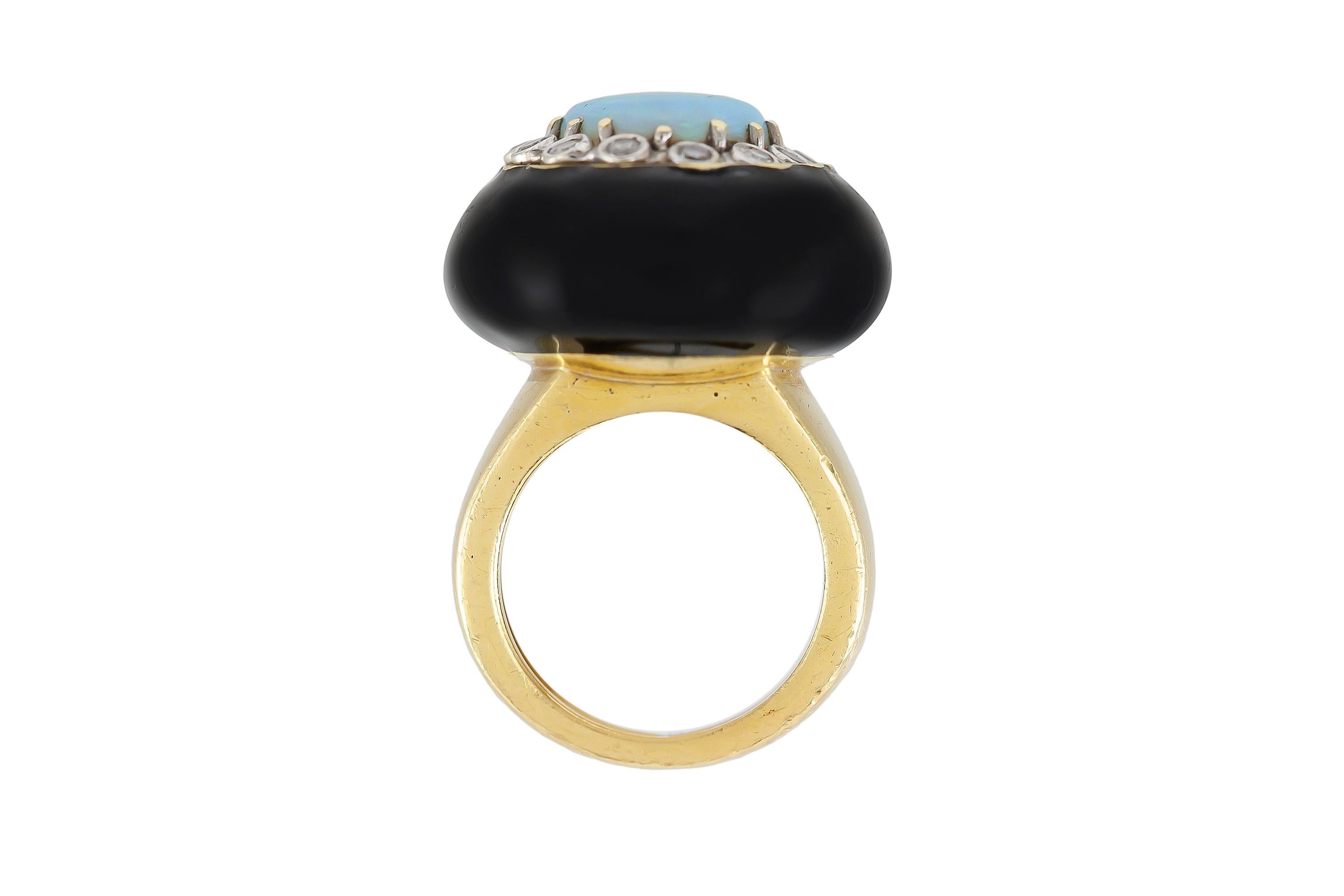Cocktail ring finely crafted in 18 k gold with diamonds weighing a total of 0.20 k, and an onyx and an opal. Circa 1960.