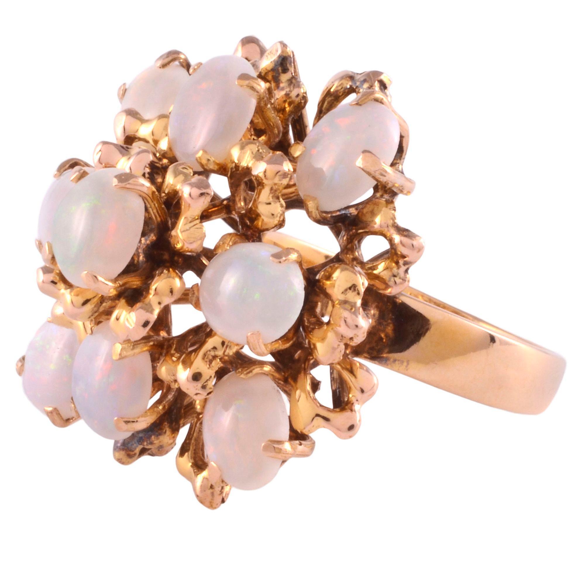 Vintage oval opal cocktail ring, circa 1950. This 12 karat yellow gold cocktail ring has nine oval opals. The vintage opal ring is a size 6.5. [SJ SAUC1167A P]

*Resizing available for additional charge.