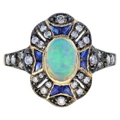 Anillo de oro amarillo con halo de ópalo ovalado y zafiro y diamantes estilo art déco