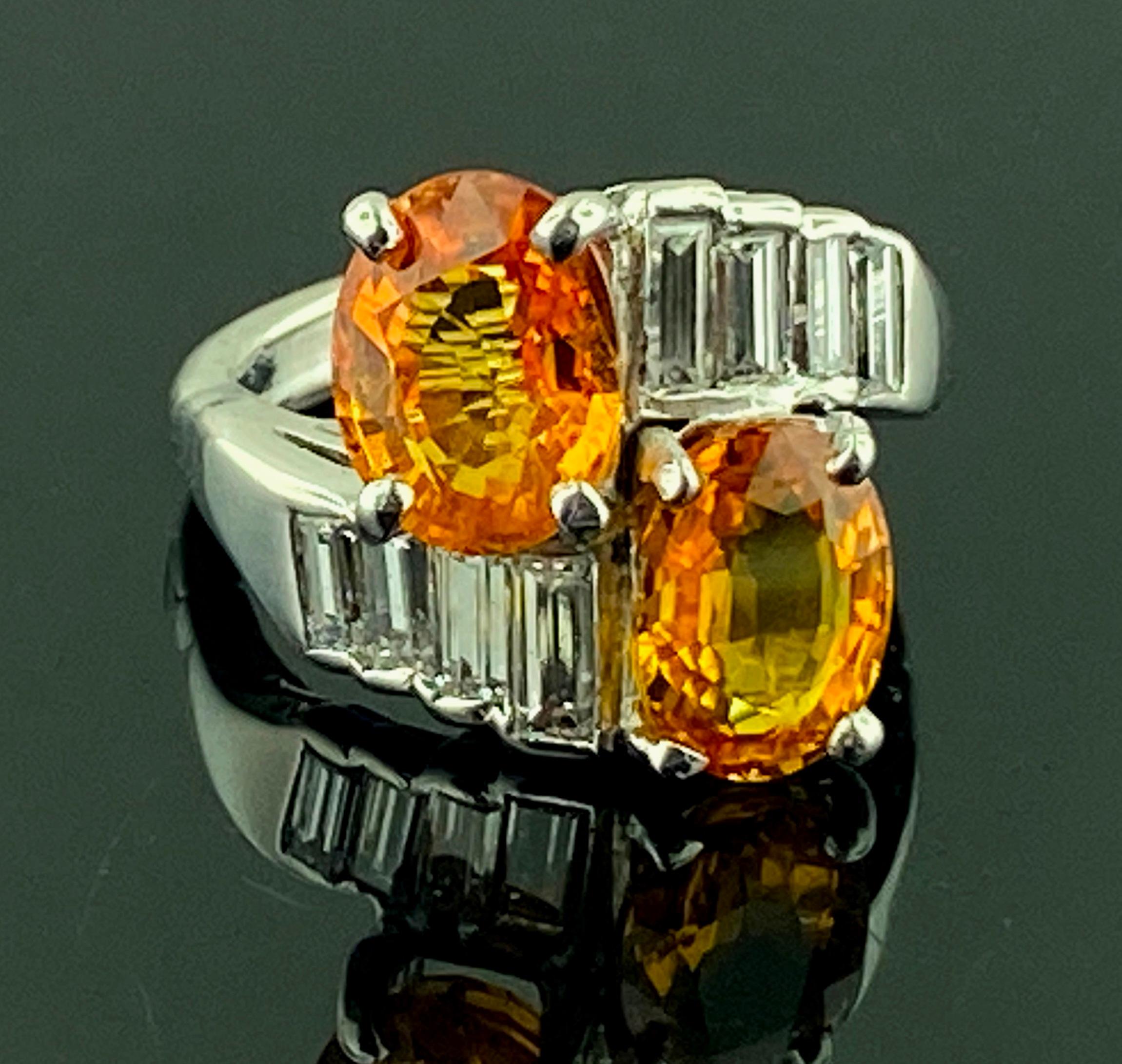 The top part of this ring that houses the two Oval cut Orange Sapphires is in Platinum.  The two Oval Orange Sapphires weigh 2.55 carats and 2.19 carats for a total weight of 4.75 carats.  The mounting, which is 14 karat white gold, contains 8