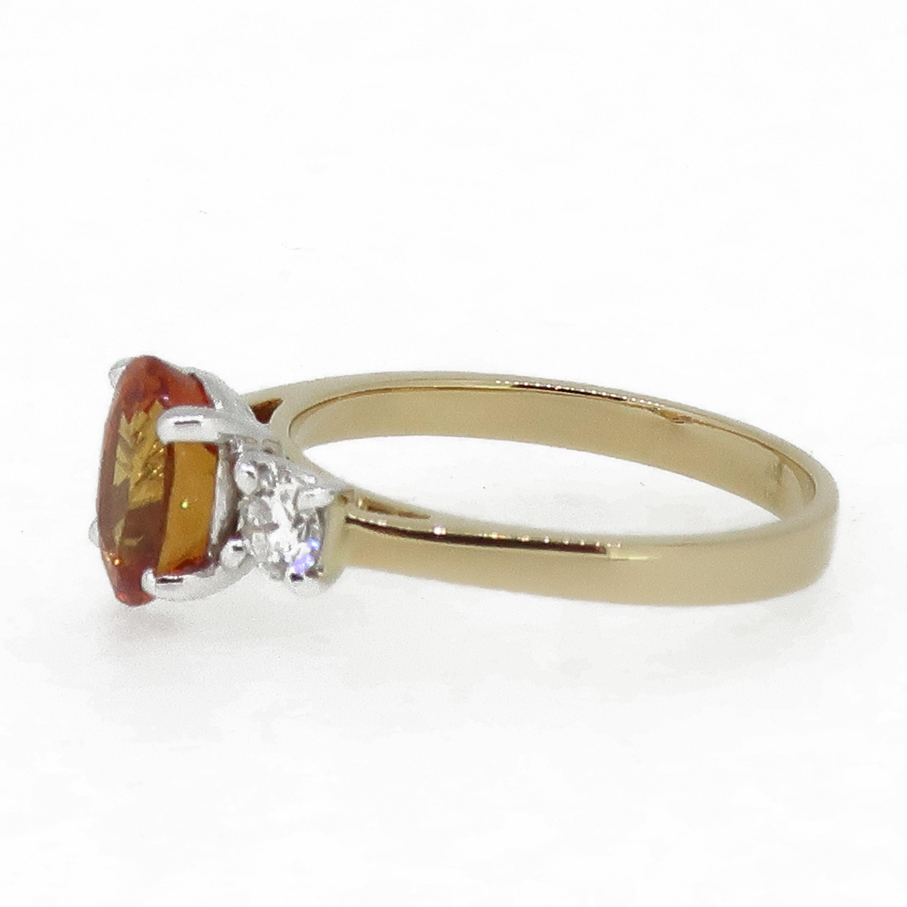 Oval Orange Sapphire and Diamond Three-Stone Ring 18 Karat Yellow and White Gold

A vibrant oval orange sapphire & diamond 3 stone ring. Central oval sapphire sits proud above the two diamonds in 18ct white gold four claws, flanked by a round