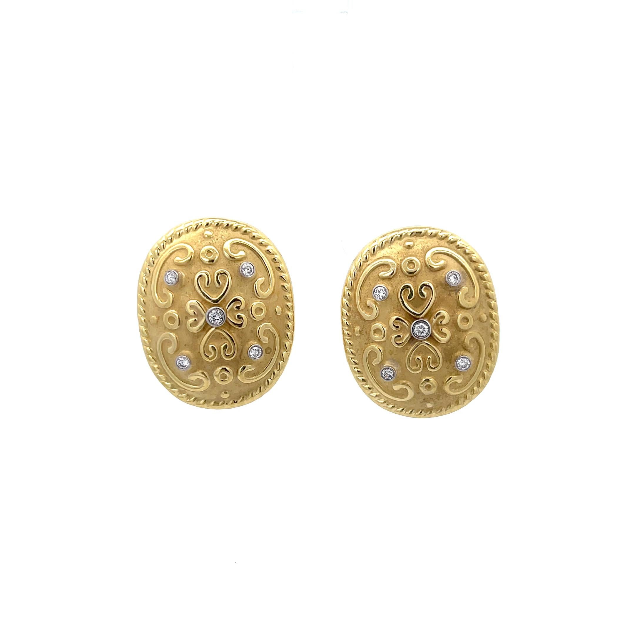 Oval Ornate Diamond Clip-on Earrings in 18K Yellow Gold. The earrings feature approximately 0.36ctw of bezel set brilliant round diamonds. The earrings measure 1.25 inches by 1 inch and weigh 13.49 grams.