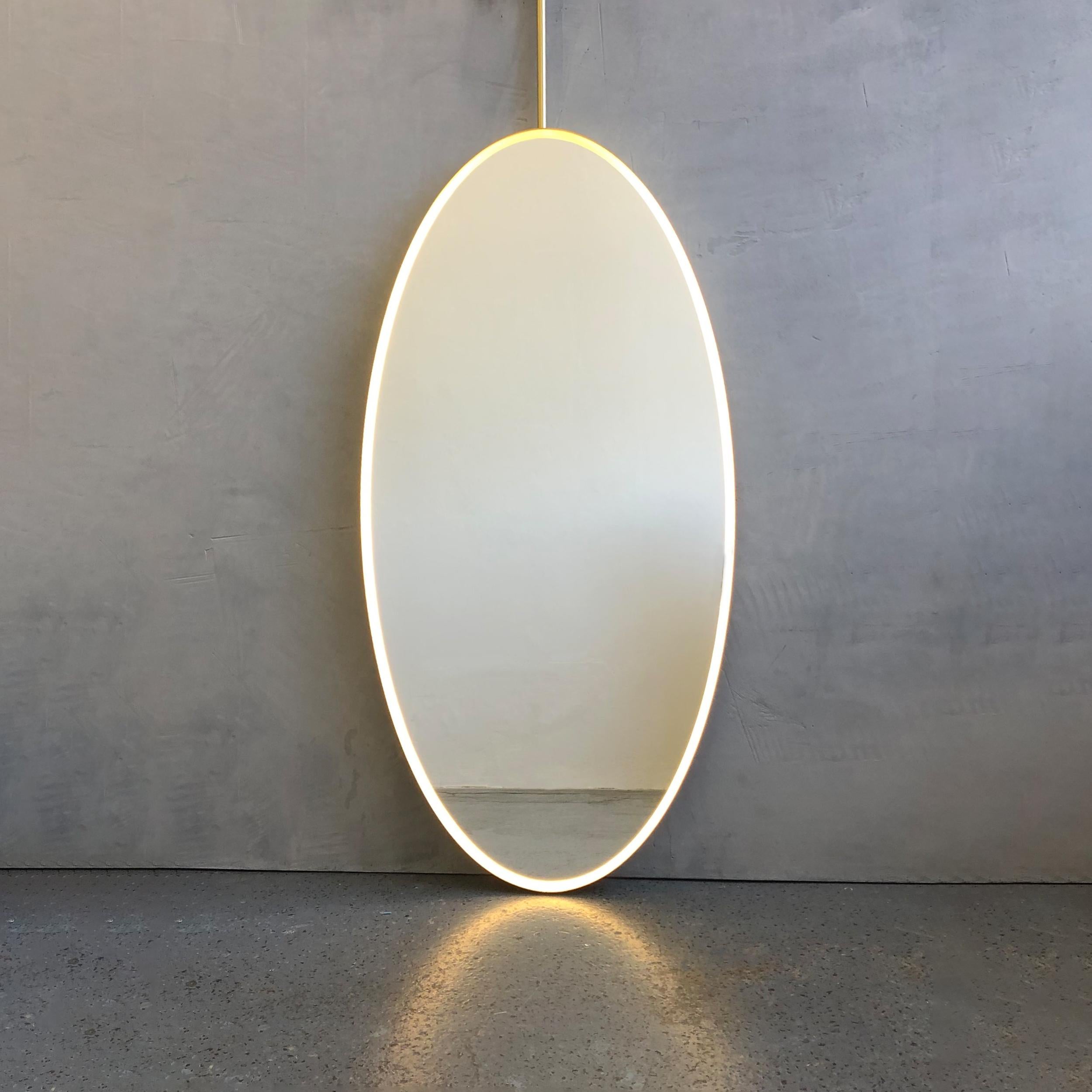 Superbe miroir de forme ovale Ovalis™ suspendu au plafond avec un élégant cadre en laiton brossé et un éclairage frontal sur un côté.

Dimensions du miroir : 100cm (39.4