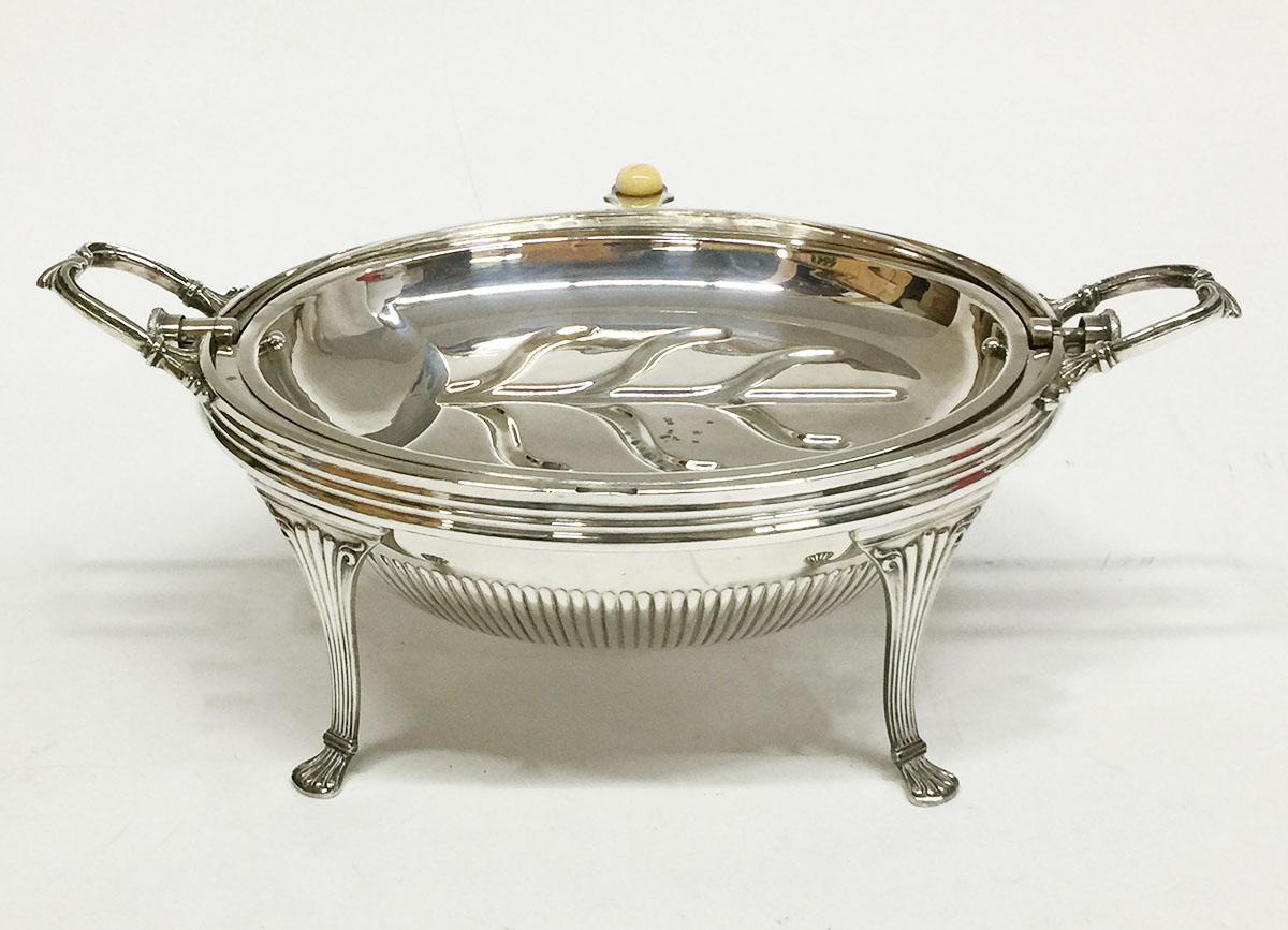 Plato ovalado plateado con tapa basculante de Cooper Brothers Sheffield, Inglaterra

Servidor de ostras abovedado, circa 1900, con asas en forma de concha y bandeja interior. El servidor es de estilo Regencia y la base tiene patas de garra de Cooper