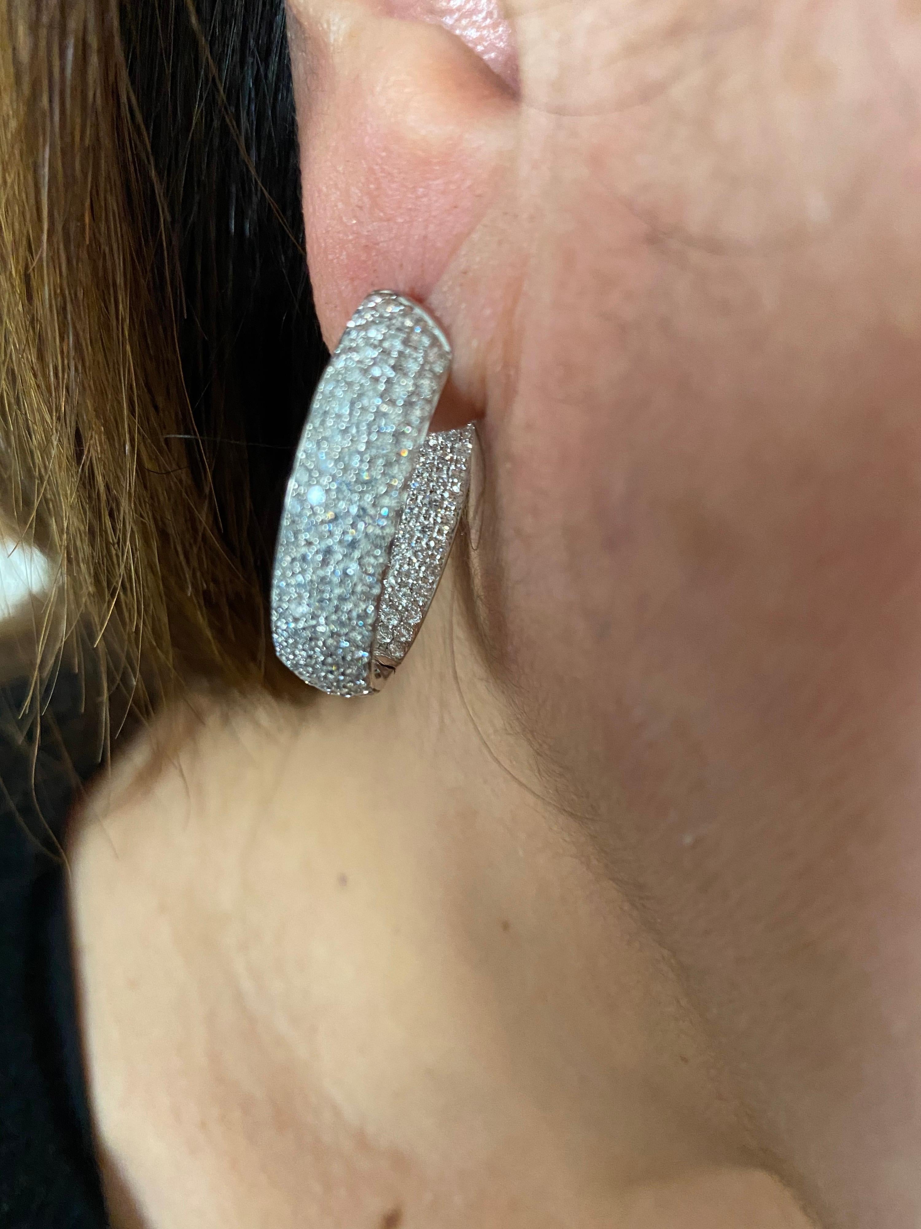 Oval shaped diamond hoop earrings set in 18K white gold. The earrings are set with 5 rows of diamonds inside and out in a Pave' setting. The color of the stones are F, the clarity is VS1-VS2. The total carat weight is 5.55 carats. The earrings are