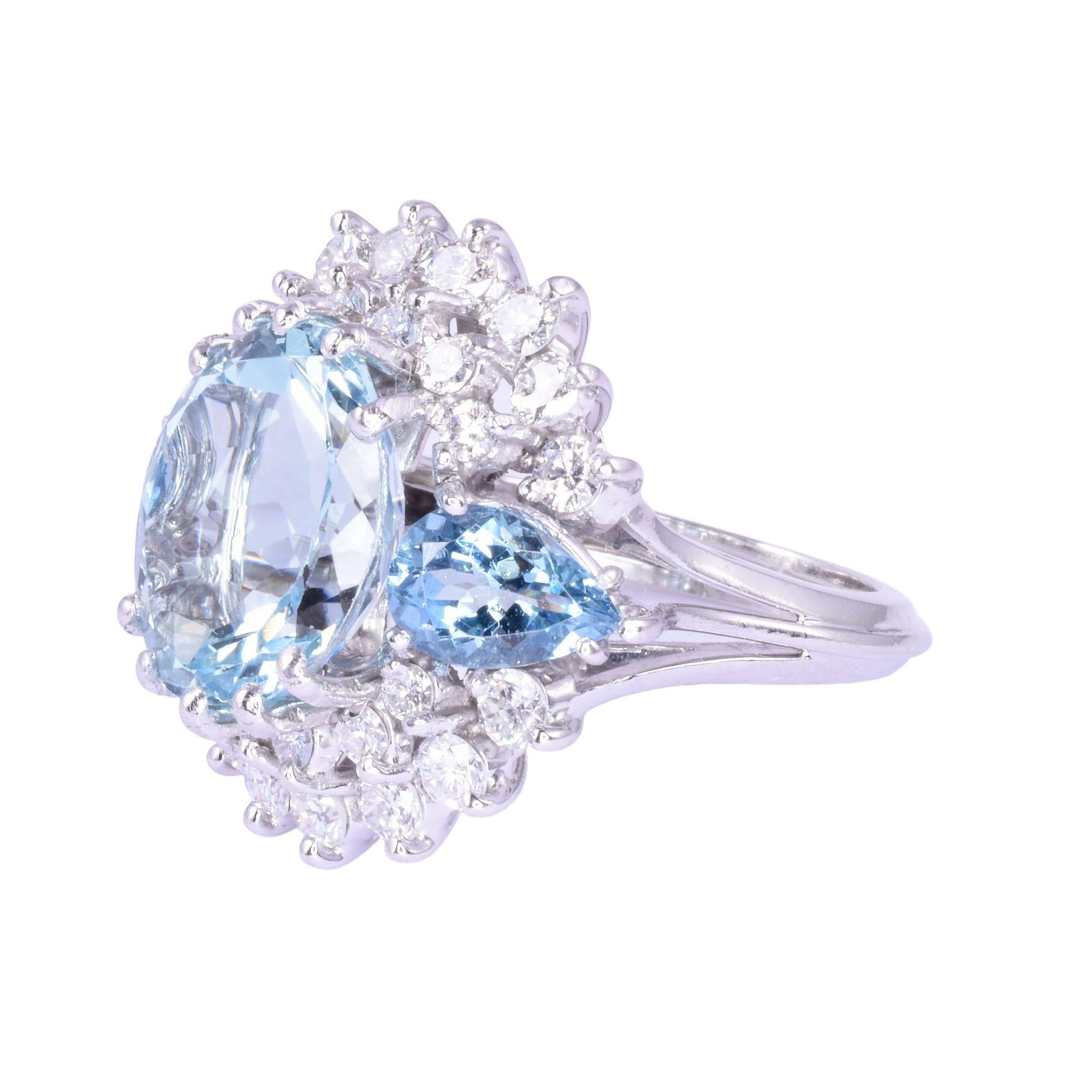 Estate oval & pear aquamarine ring. This platinum ring features an oval aquamarine center at 4.86 carats flanked by pear aquamarine at 1.08 carat total weight. There are also 26 full cut accent diamonds at 1.00 carat total weight with VS1-SI2