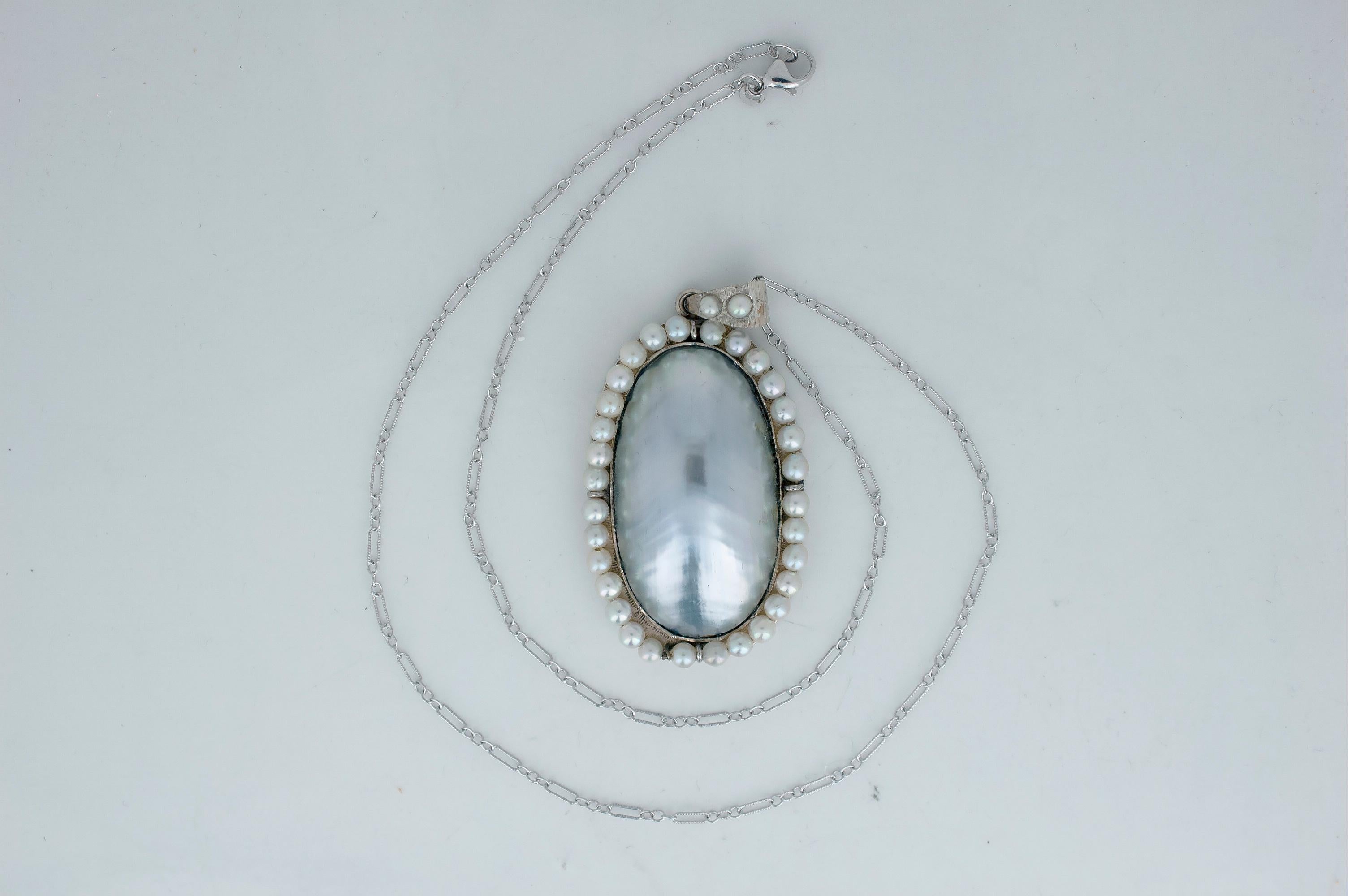 As unique as a pearl is this piece has such a unique look featuring a large natural Mabe' Pearl and over thirty three round pearls that range in size from 3-3.1mm.  The pearls are set in a unusual white gold wire setting that allows the pearls to