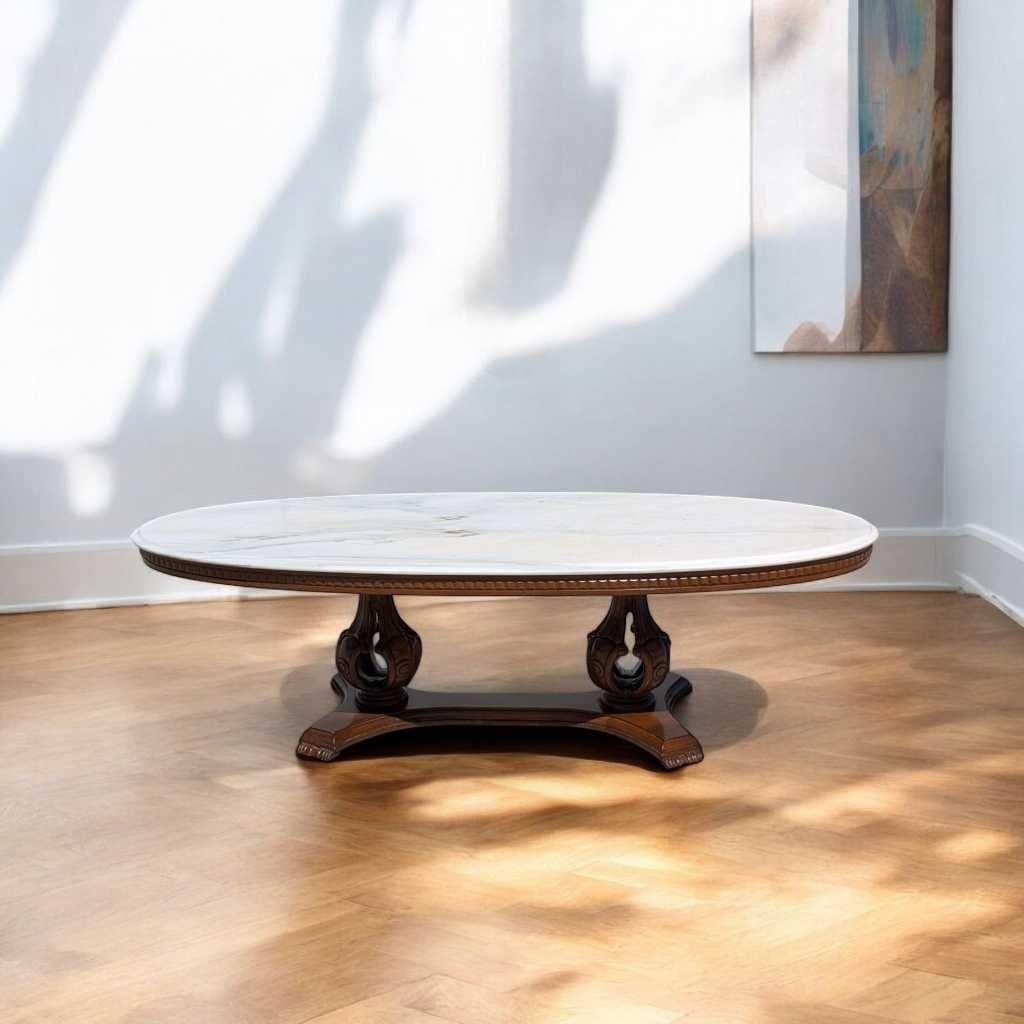 A distinctive oval coffee table in the mid-century Italian tradition, crafted from rich carved wood and topped with elegant white marble. The double pedestal base showcases intricate scrollwork and refined craftsmanship, creating a dramatic contrast