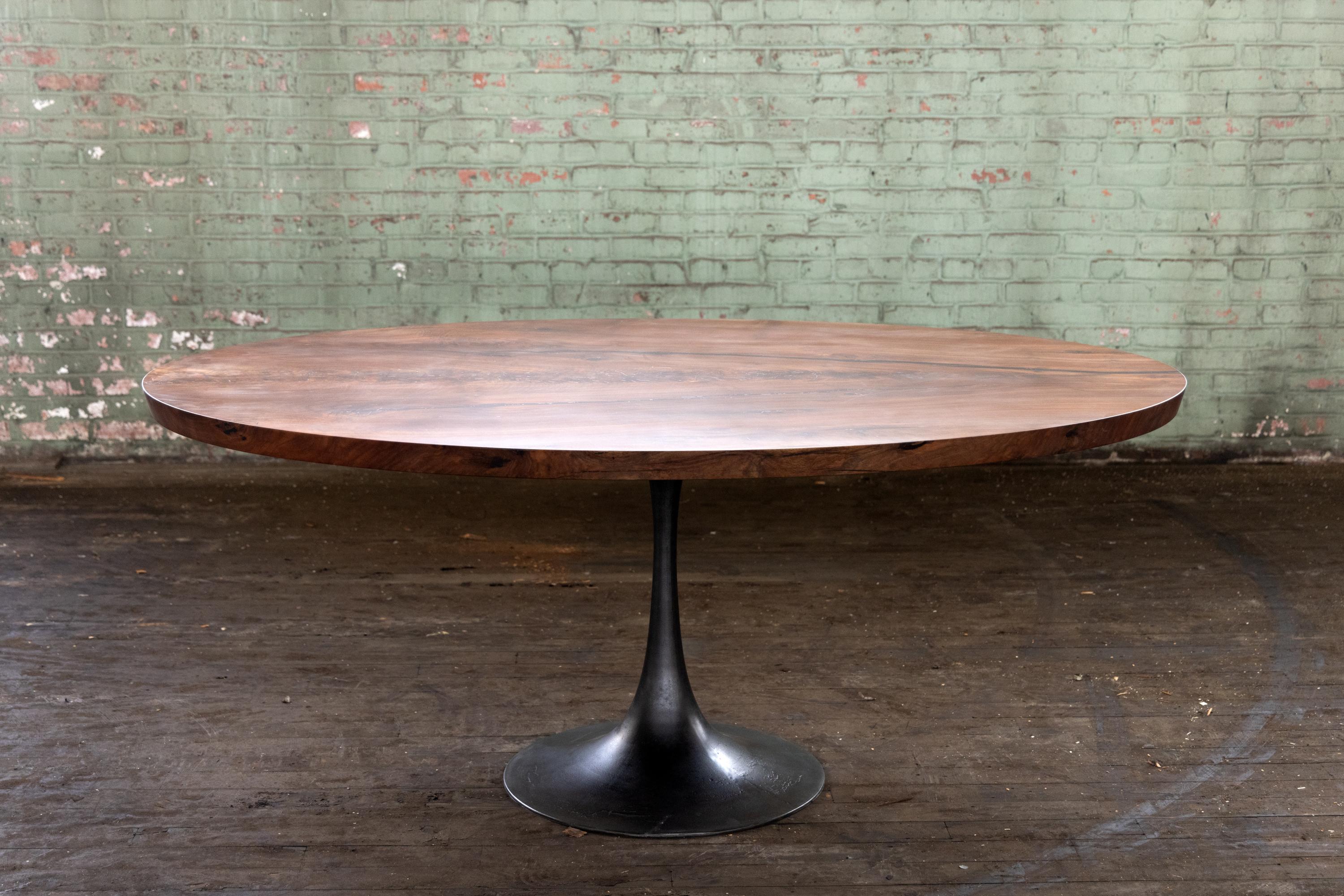The Amicalola base captures the room set against an oval table top. This pedestal base is hand cast by the artisans at Sloss Furnaces historic foundry in Birmingham to look beautiful and function out of the way of diner's feet. Rich with Mid-Century