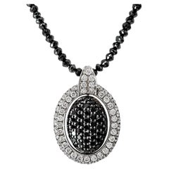 Colgante Oval con Centro de Diamante Blanco y Negro Reversible en Cadena de Diamantes Negros