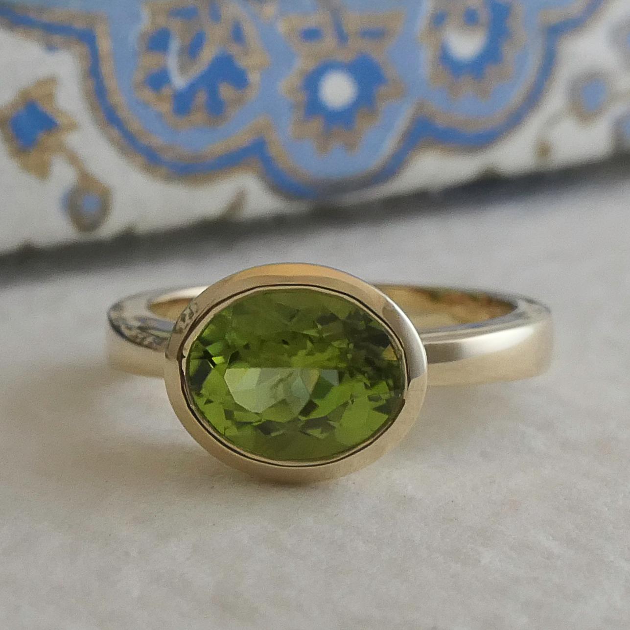 7.2x9.2mm natural peridot is bezel set in 14kt yellow gold.

Ring Size is 7