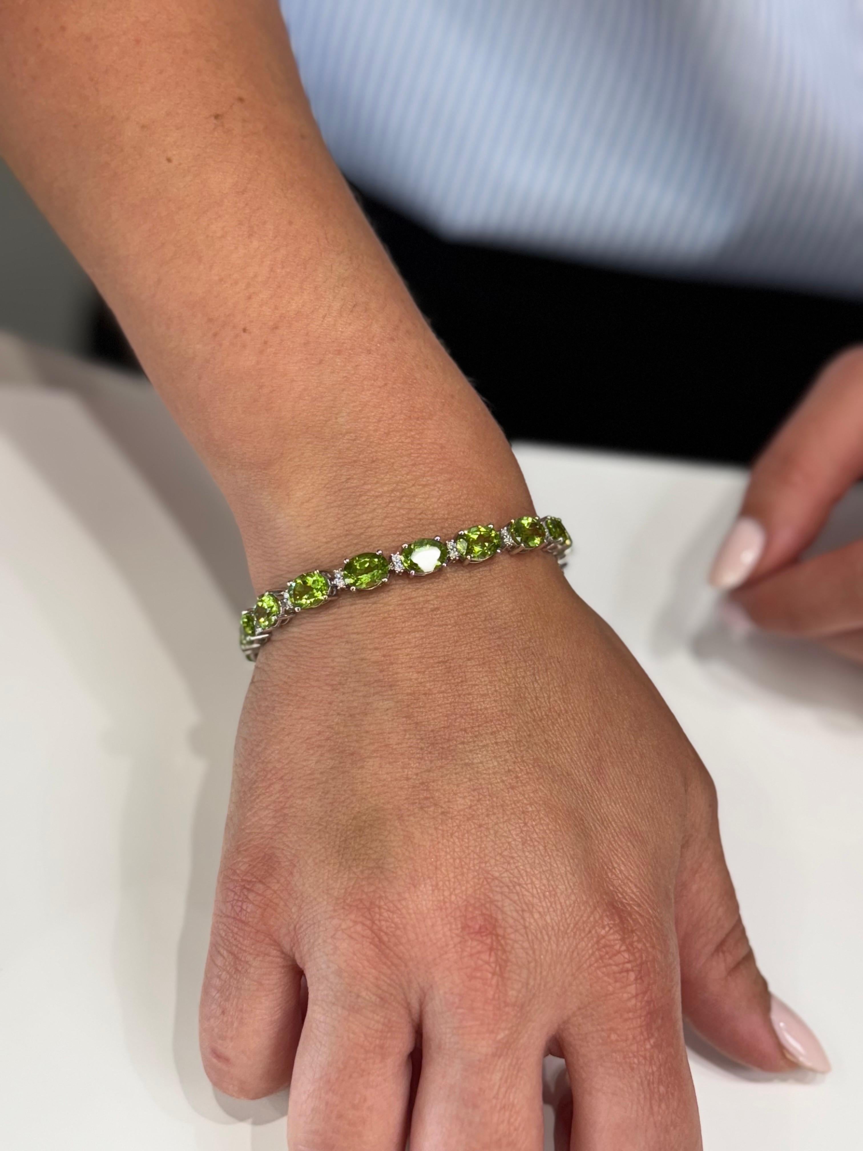 14K white gold bracelet with oval peridots weighing 28.47 carats total and diamonds weighing 0.44 carats total.  The bracelet has a clasp and safety latch.  

- Length is 7 inches