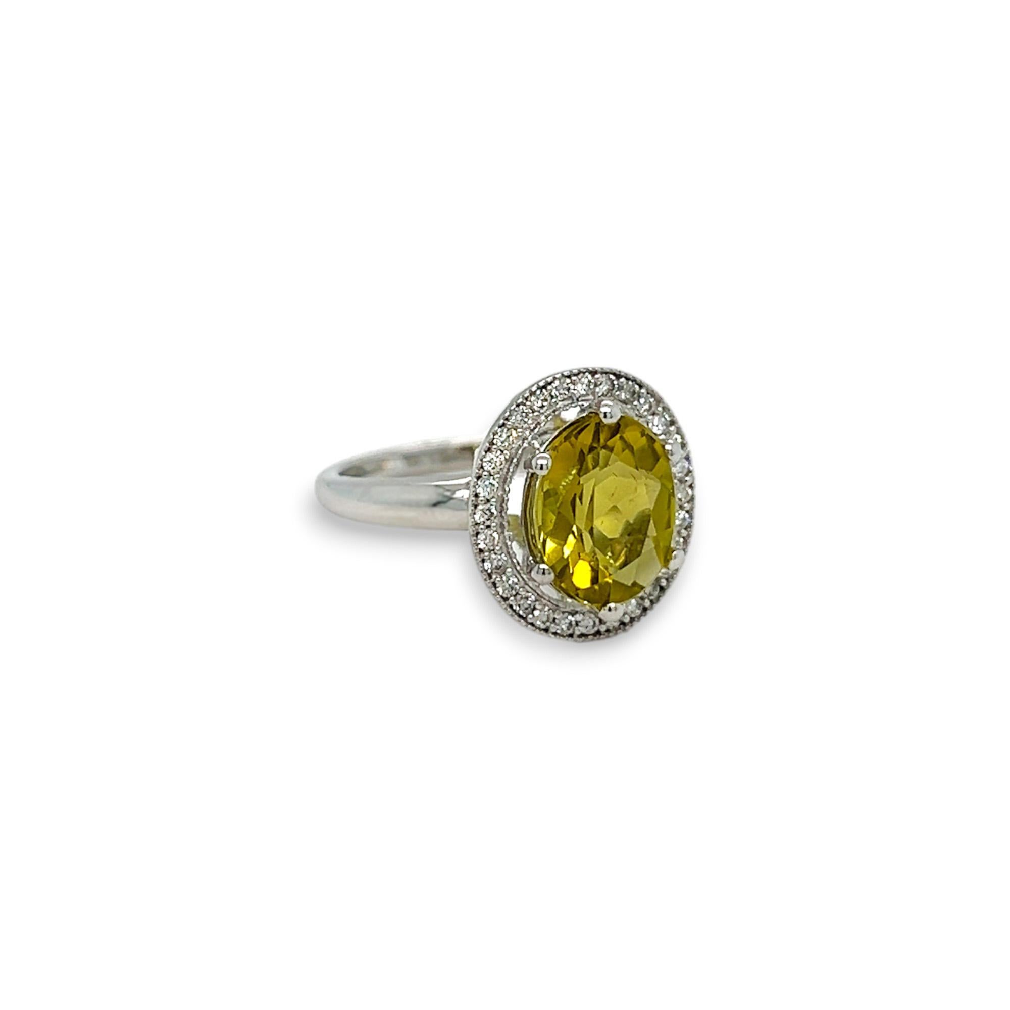 This gorgeous ring features a 2.57 carat oval peridot center stone with a halo of round diamonds which total 0.23 carats. The diamonds are G/H color and SI clarity. Set in 14k white gold. Ring can be sized upon purchase.