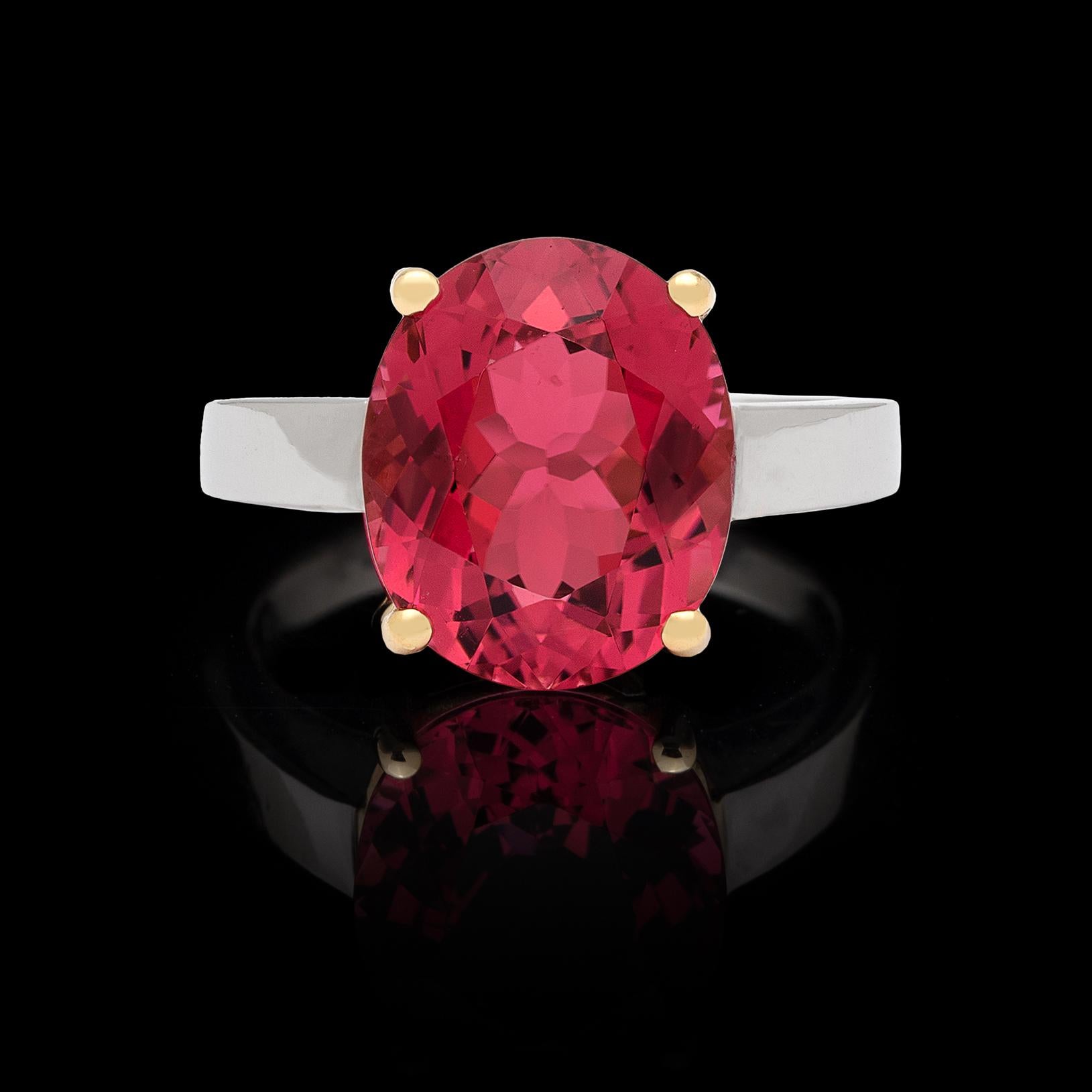 Be on trend with this orangey-pink oval tourmaline ring! Weighing 4.28 carats, and set in 18k yellow gold with a platinum mount, this unique and contemporary ring is full of life and glorious color.  The ring weighs 7.5 grams and is currently size