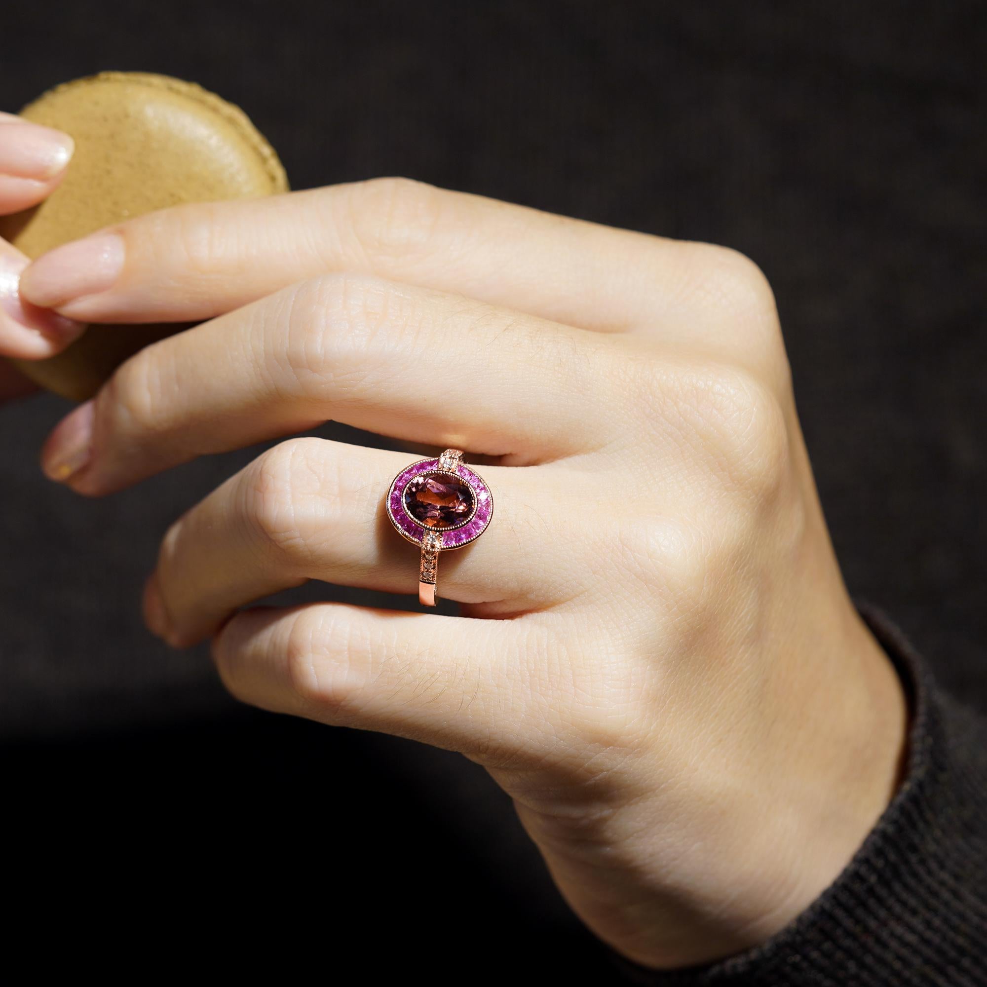 Romantic and radiant, this Art Deco-style engagement ring is a celebration of bold elegance and timeless charm. At its heart, a luscious oval pink tourmaline glows in a sleek bezel setting, capturing the essence of feminine grace. A halo of